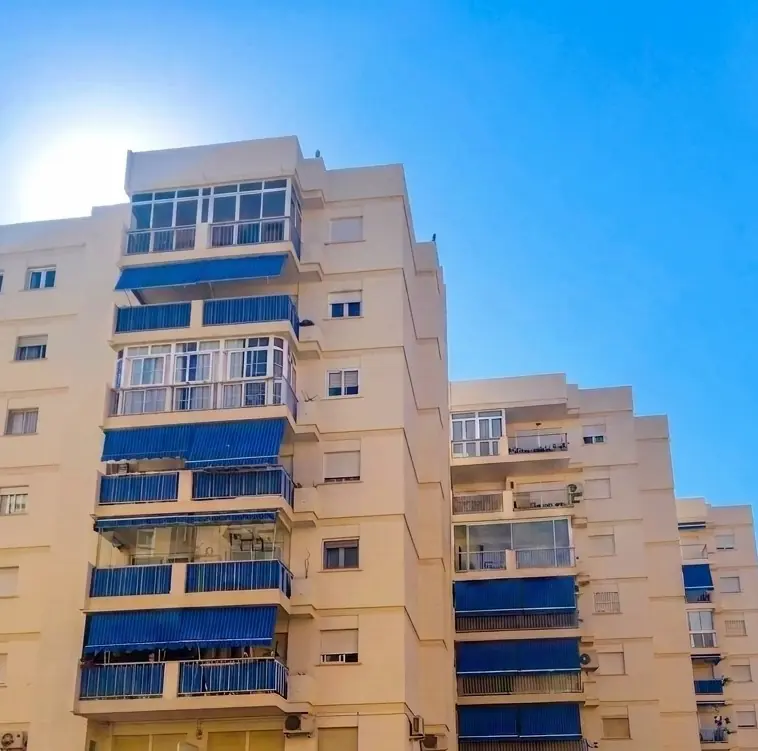Edificio amarillo con toldos azules