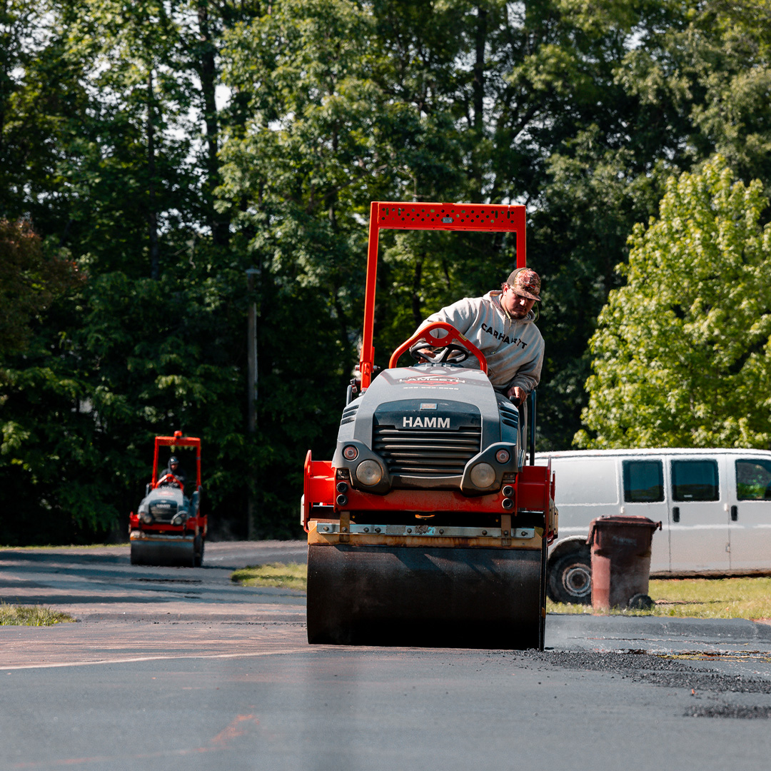 Two HAMM roller compactors working in tandem to compact fresh asphalt on a residential street at Oakwood Forest Community, Greensboro NC