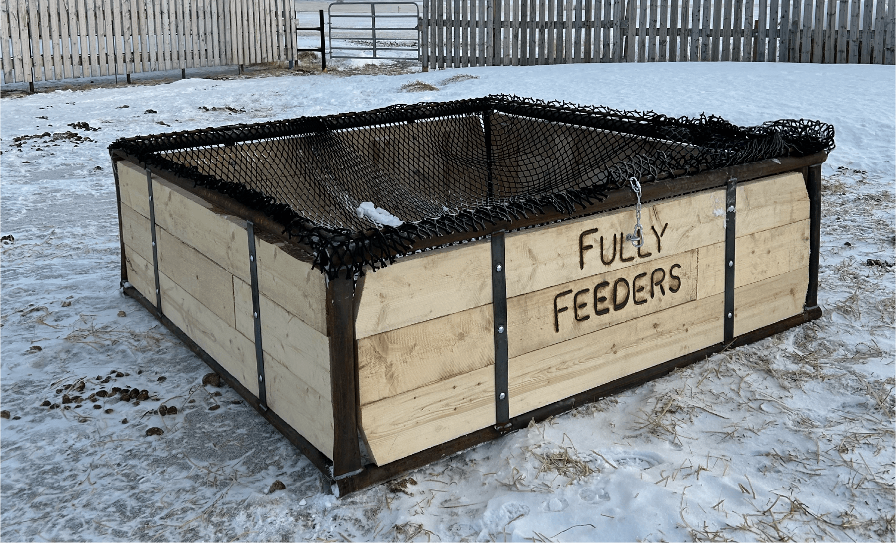 Custom-built round bale horse feeder in a Saskatchewan winter pasture.
