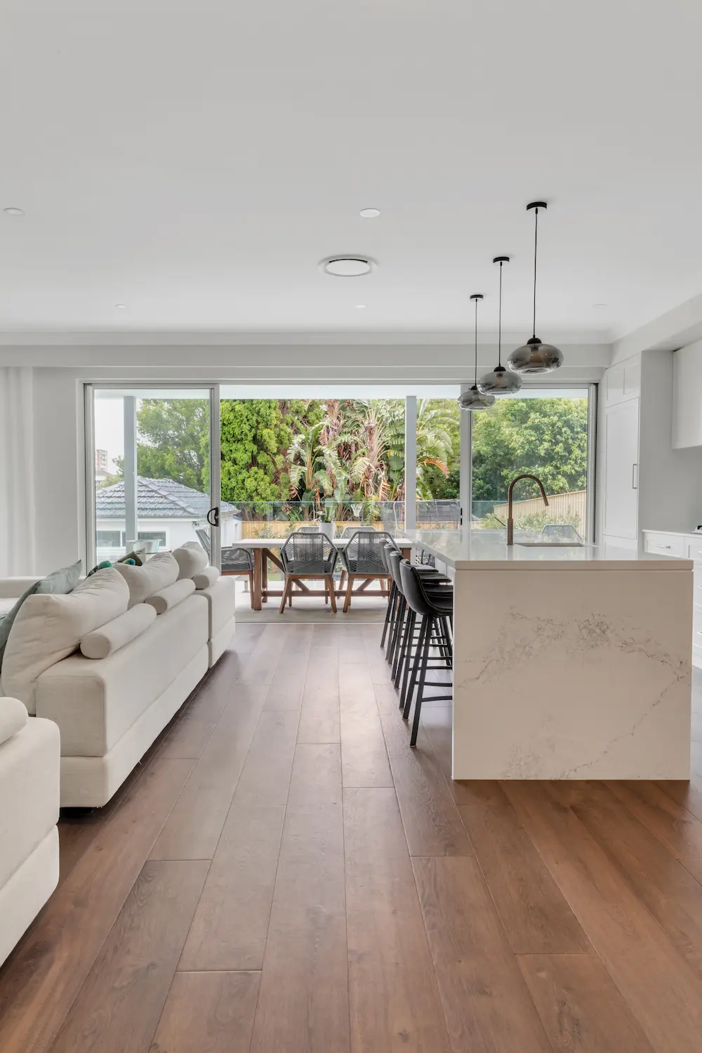 Open plan kitchen and living area with island and large windows in Cremorne Sydney
