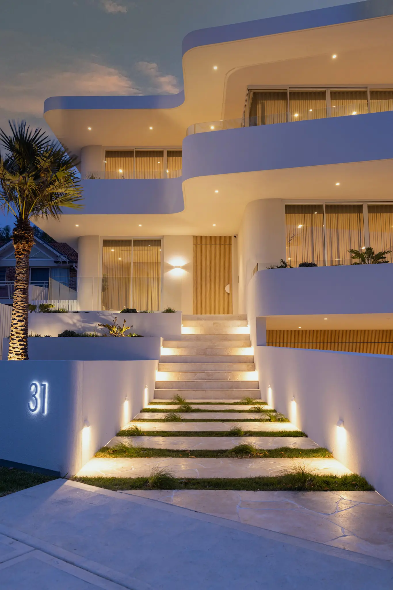 Modern home exterior with curved facade and lighting at night in Kogarah Bay Sydney