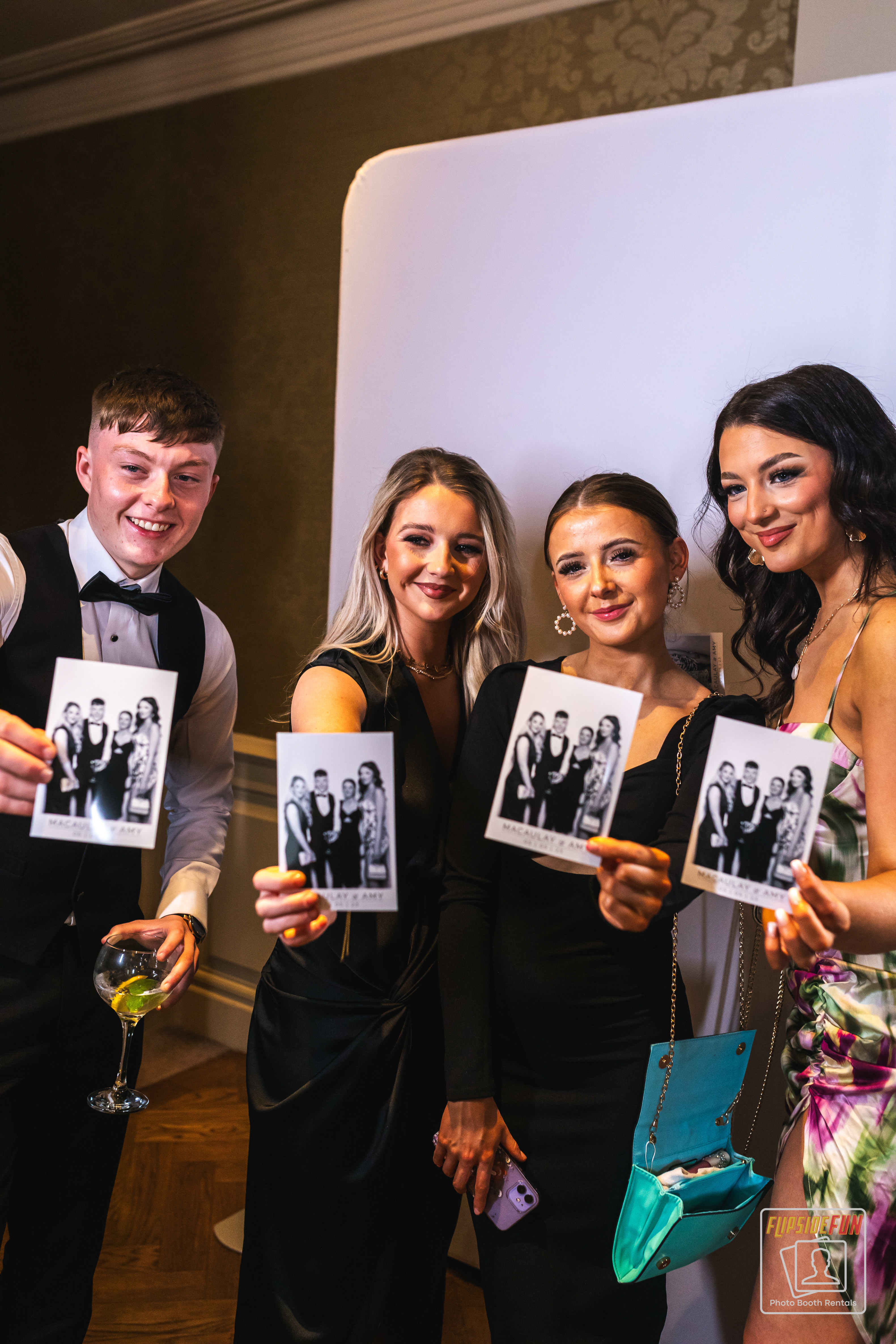 Guests holding photo booth prints at an event
