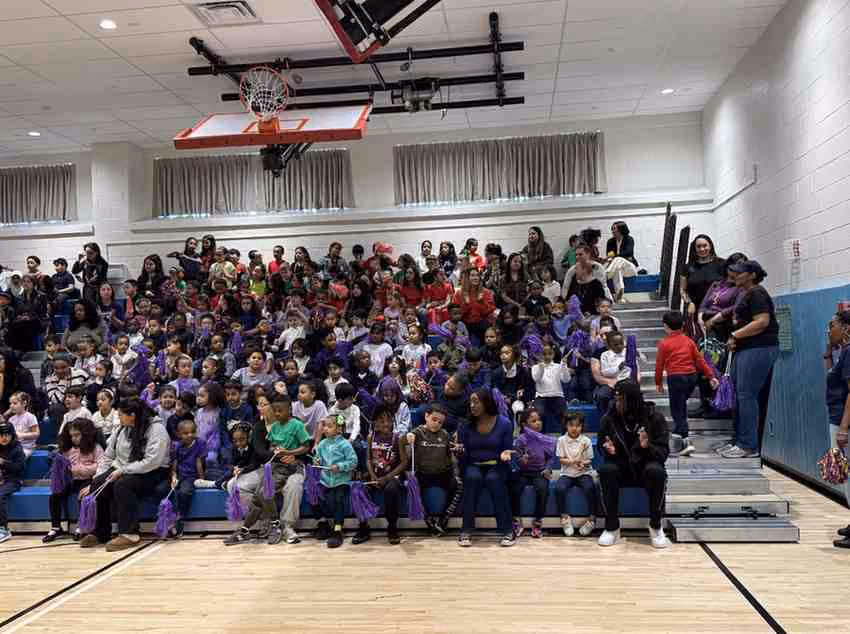 Students and families filling gymnasium bleachers during a school event