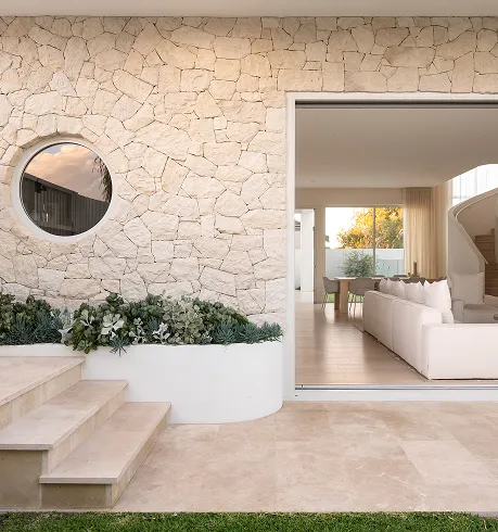 A living room with a white couch sitting on top of a lush green field.