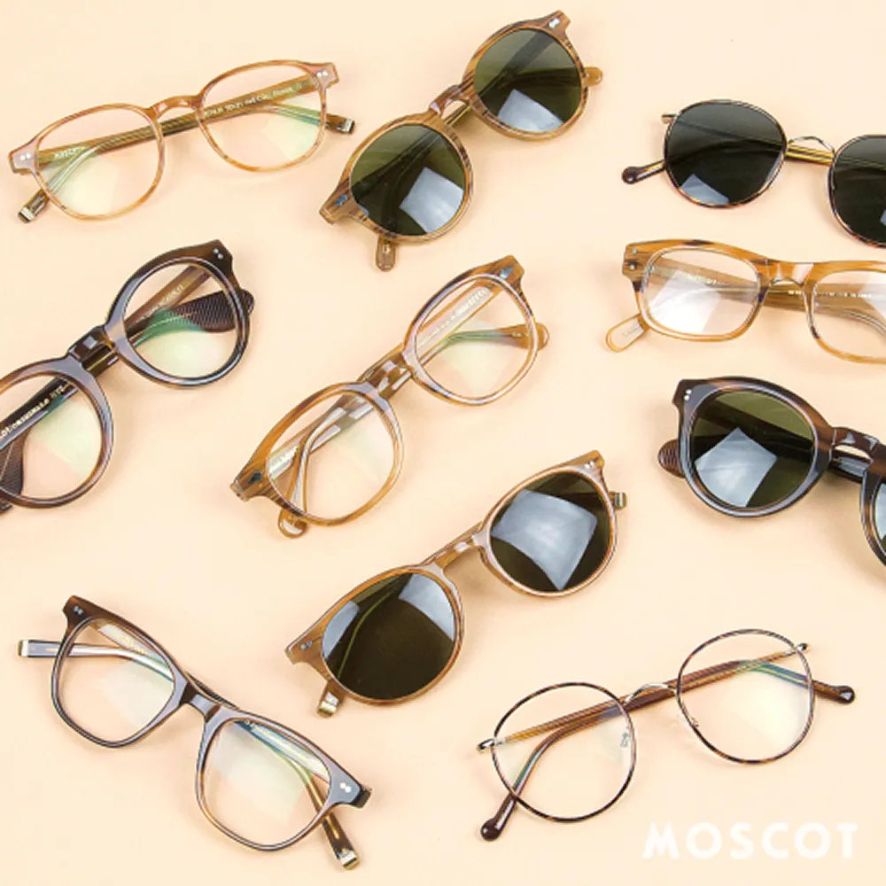 Variety of eyeglasses and sunglasses with round and square frames arranged on a beige surface.
