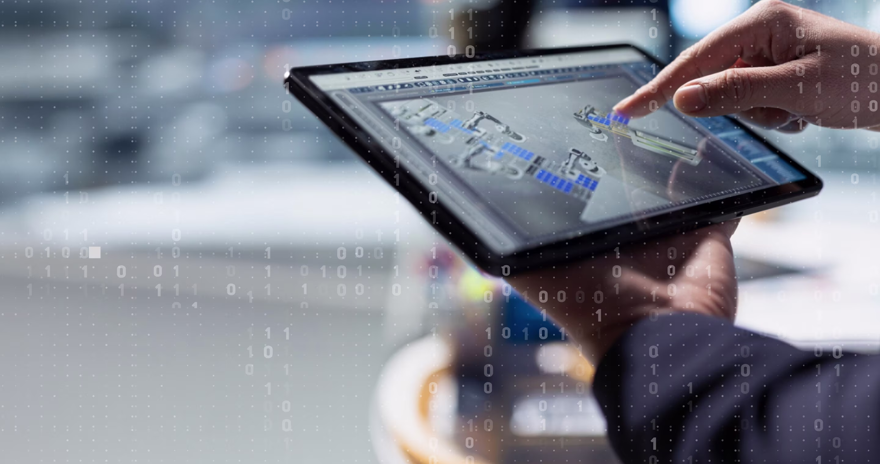 Hands holding and touching tablet displaying a digital industrial automation interface with binary code overlay.
