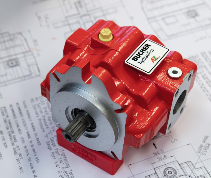 Red Bucher Hydraulics pump placed on technical blueprint drawings.