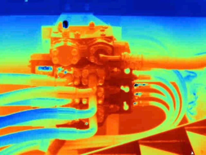 Thermal image showing heat distribution on a mechanical component with pipes and connectors.