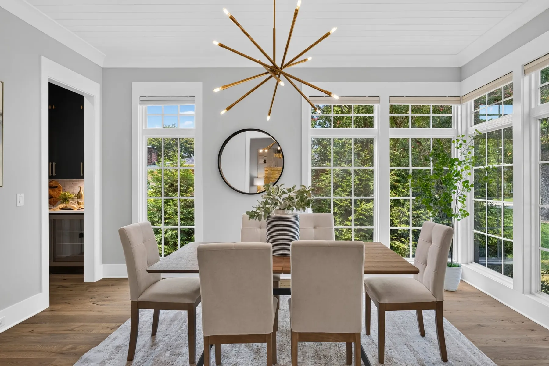 Dining room with large windows and a modern chandelier in Raleigh