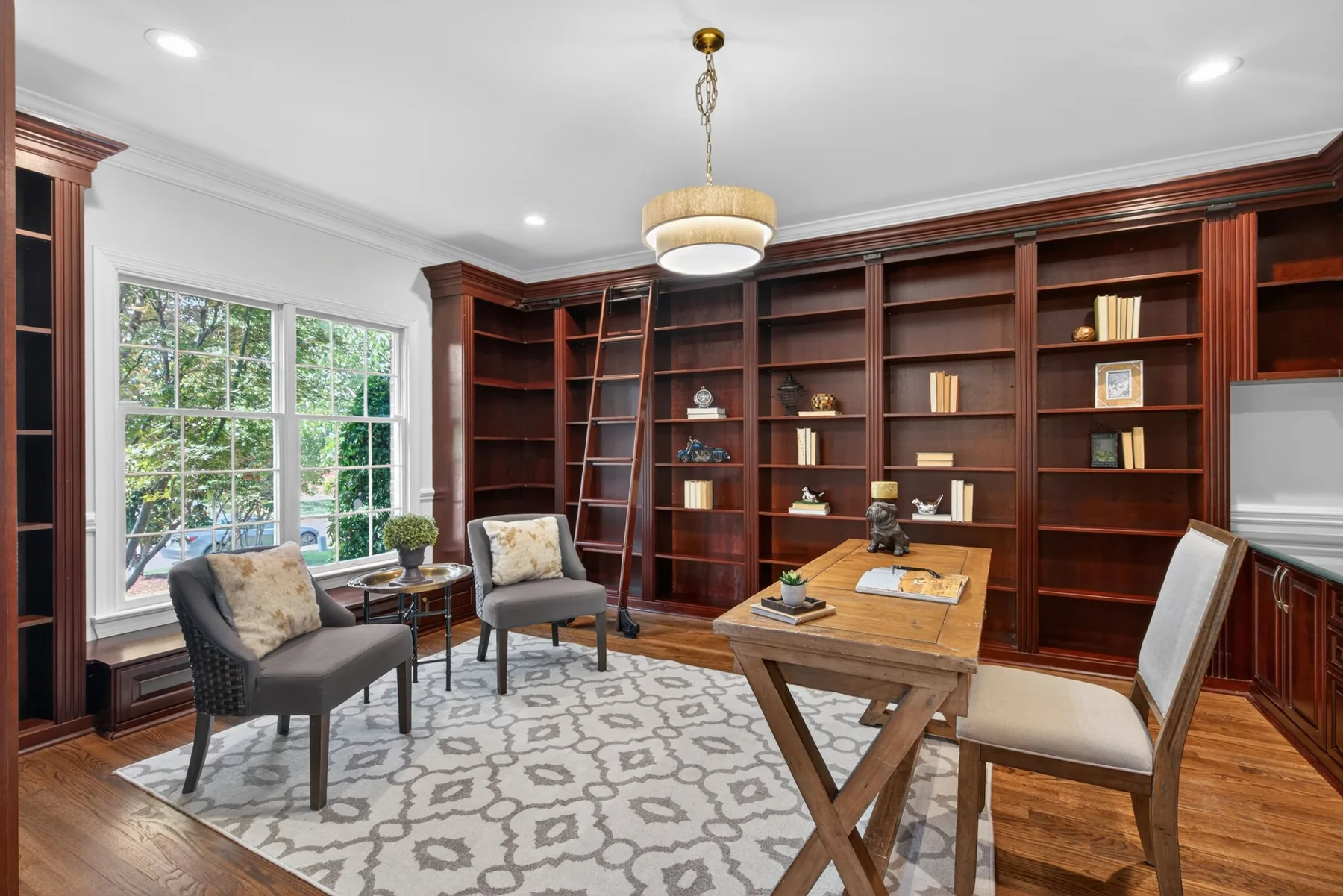 Home office with floor-to-ceiling wood built-ins and library ladder in Cary, North Carolina