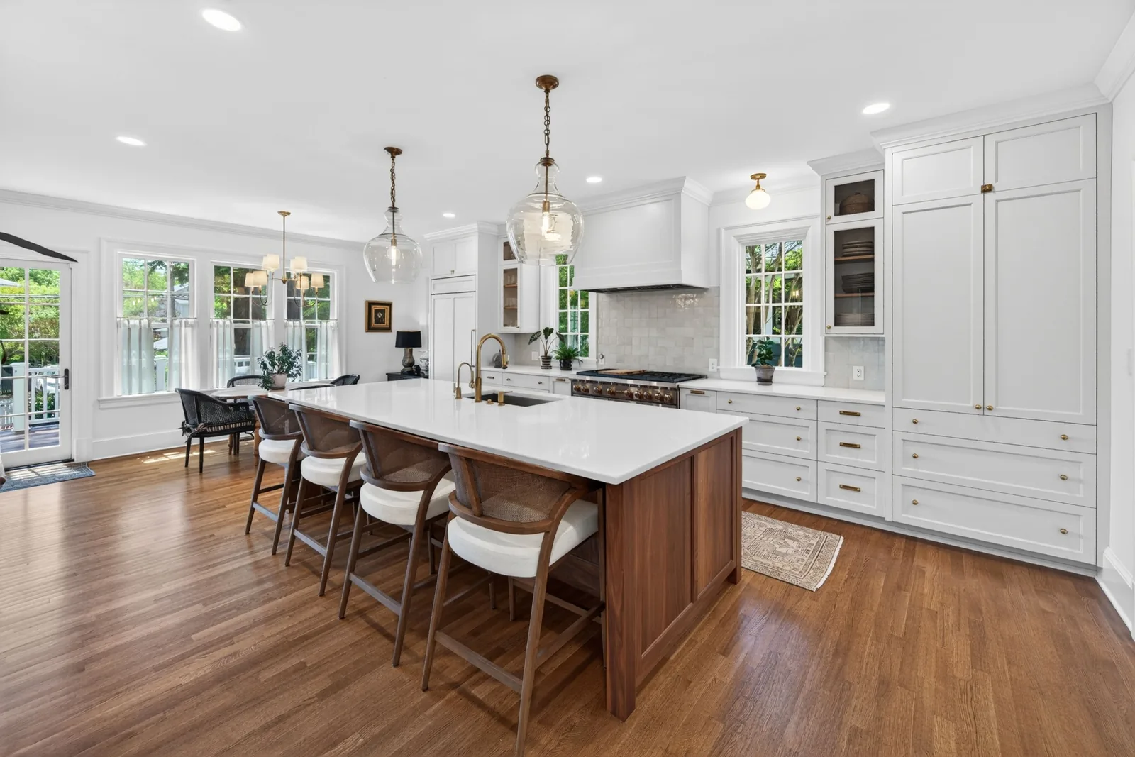 Bright custom kitchen with a large wood island, white cabinetry, and brass fixtures in a Durham, North Carolina home.