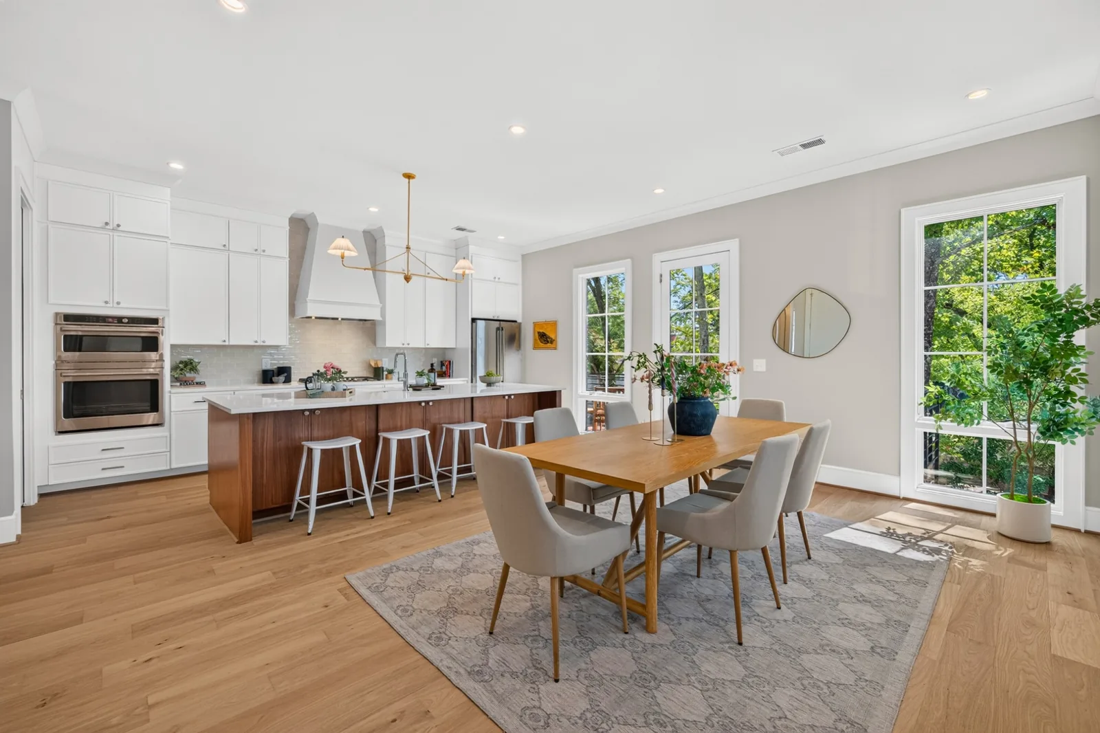 Light-filled kitchen and dining space with tall windows and warm wood finishes in a Durham, North Carolina home.