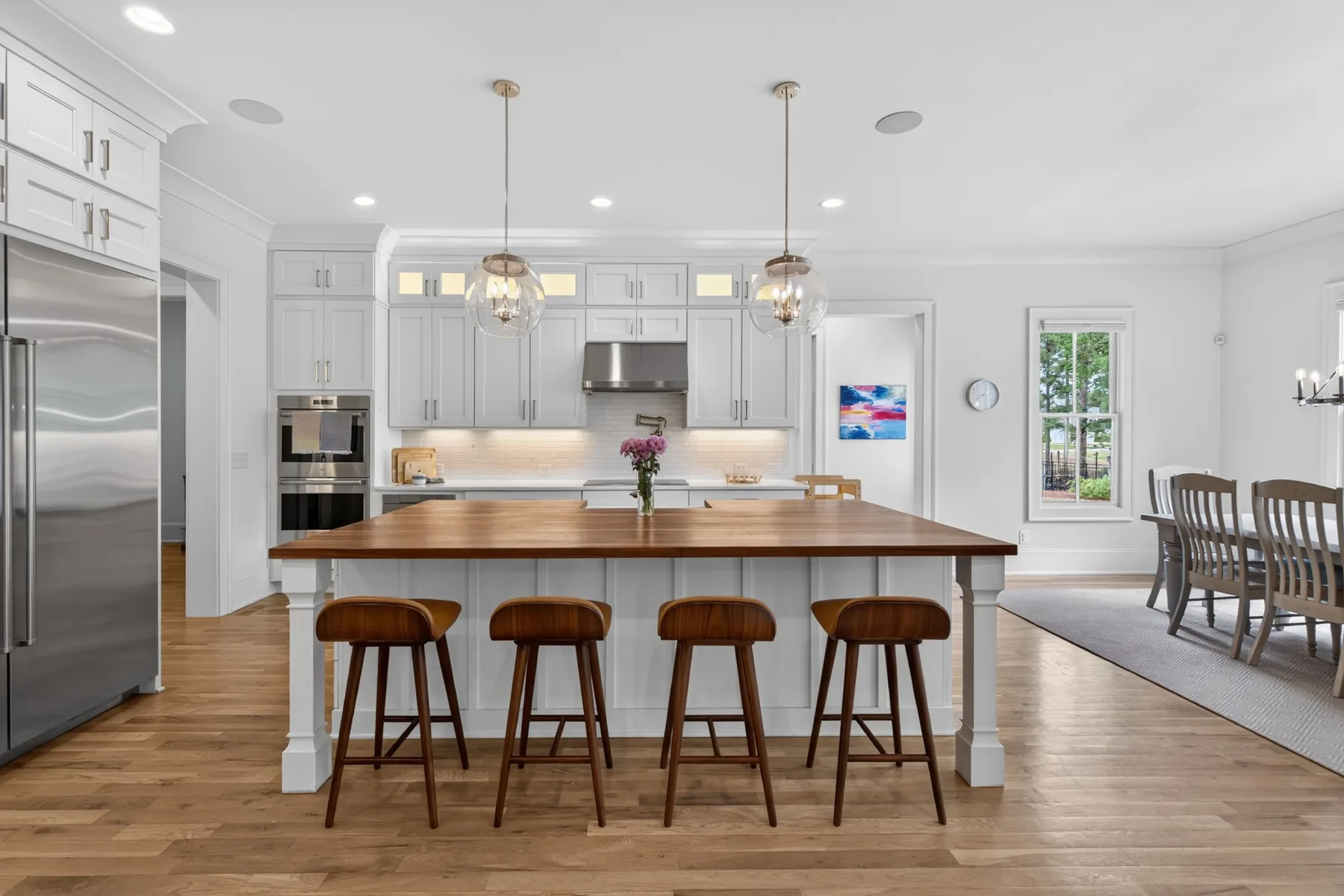 Large white kitchen with wood island photographed in a Holly Springs home