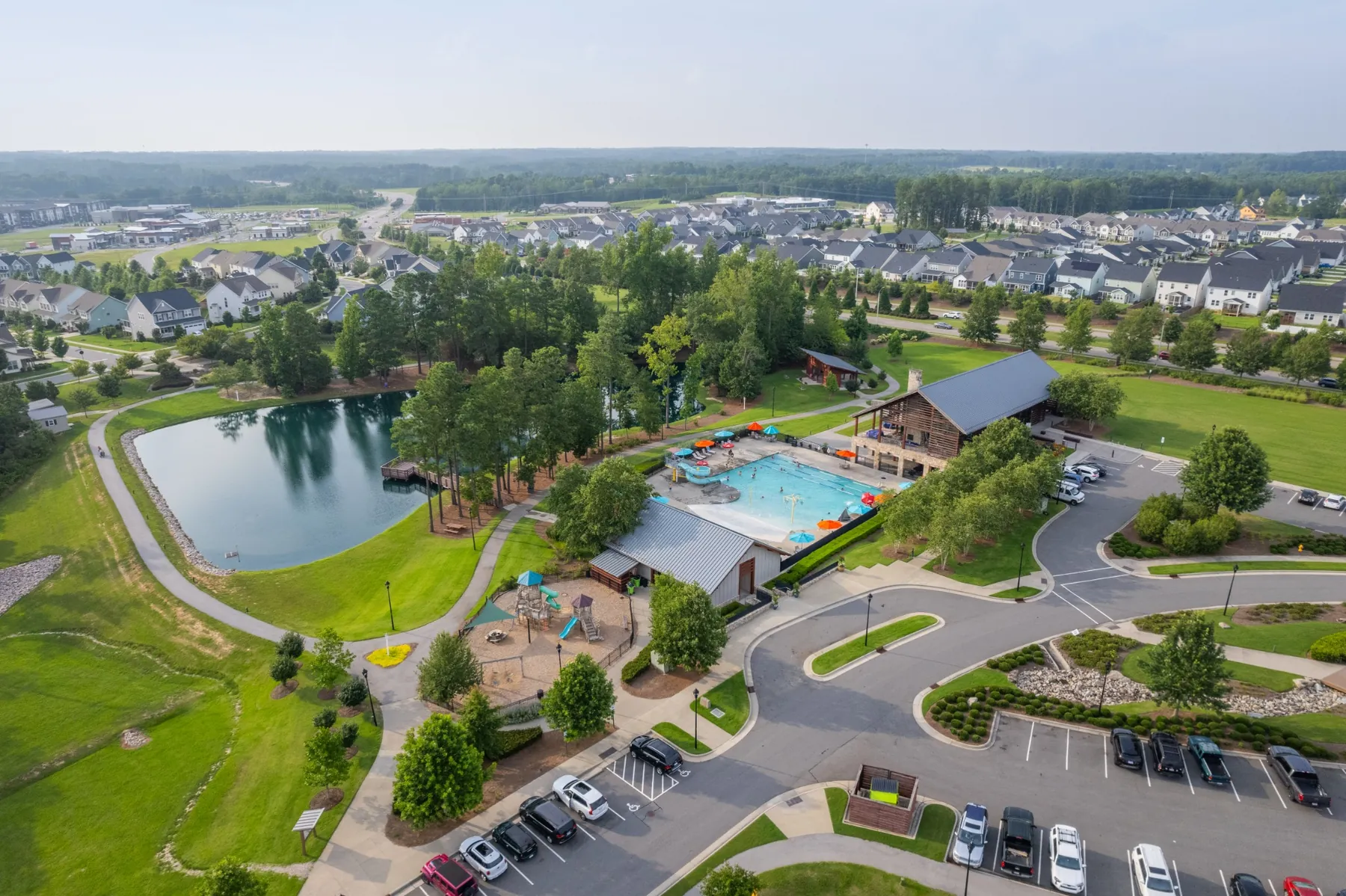Aerial view of a Wendell, NC neighborhood amenity area with pool, pond, and clubhouse