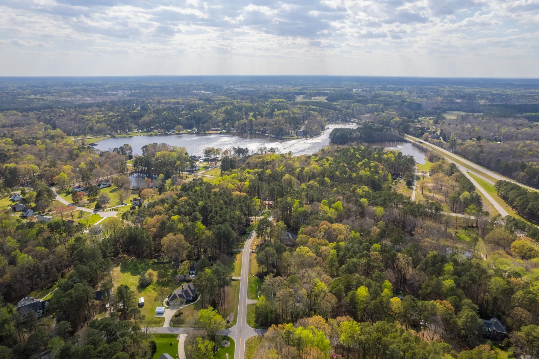 Aerial view of a lake and wooded homes near Zebulon, NC