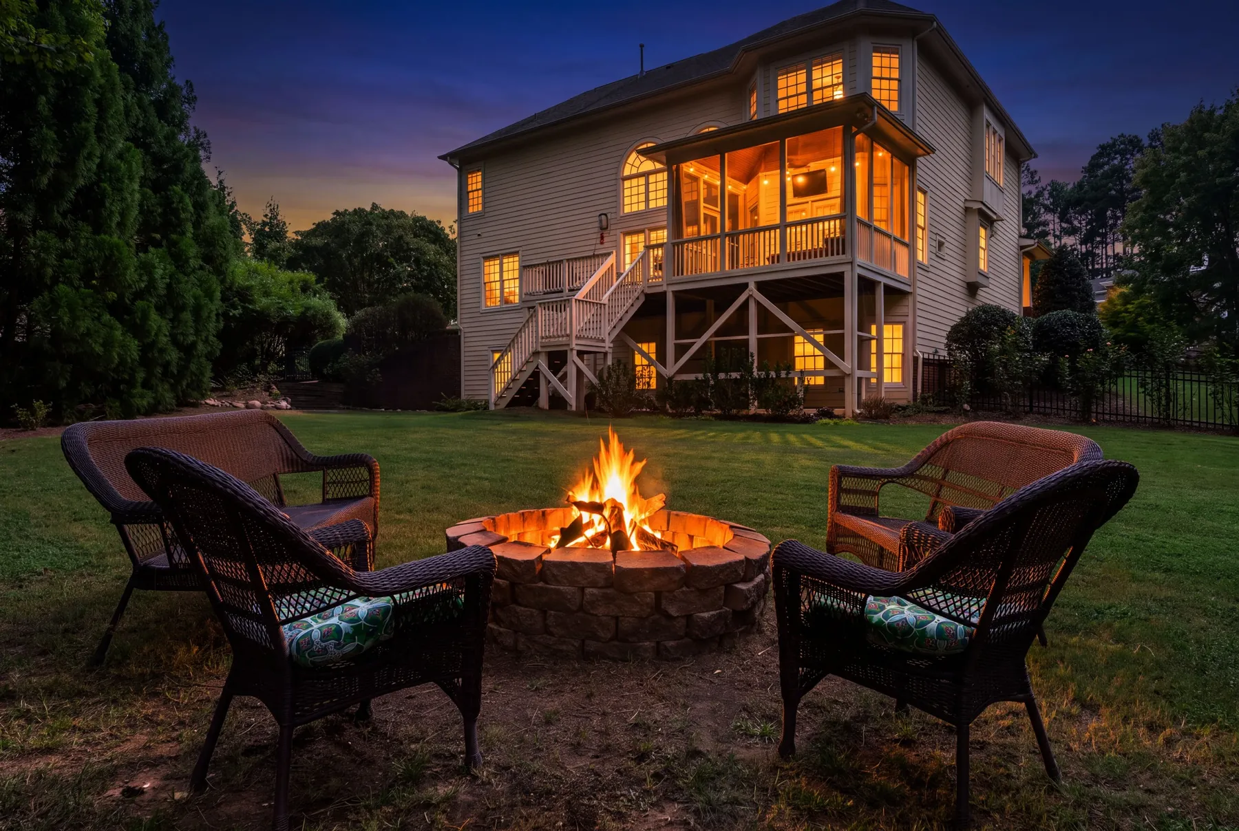 Twilight backyard with fire pit and screened porch in Zebulon, NC