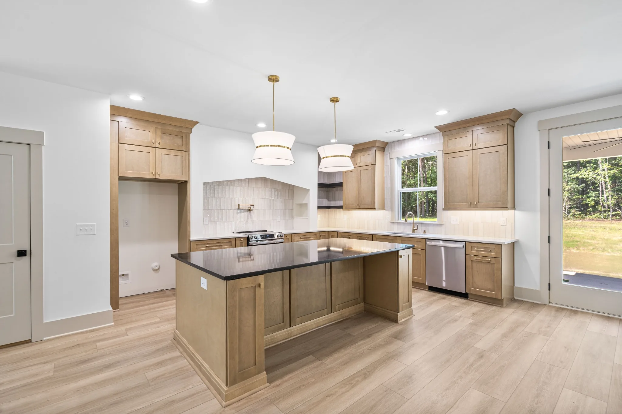 Bright modern kitchen with wood cabinetry and dark island in Smithfield, North Carolina.