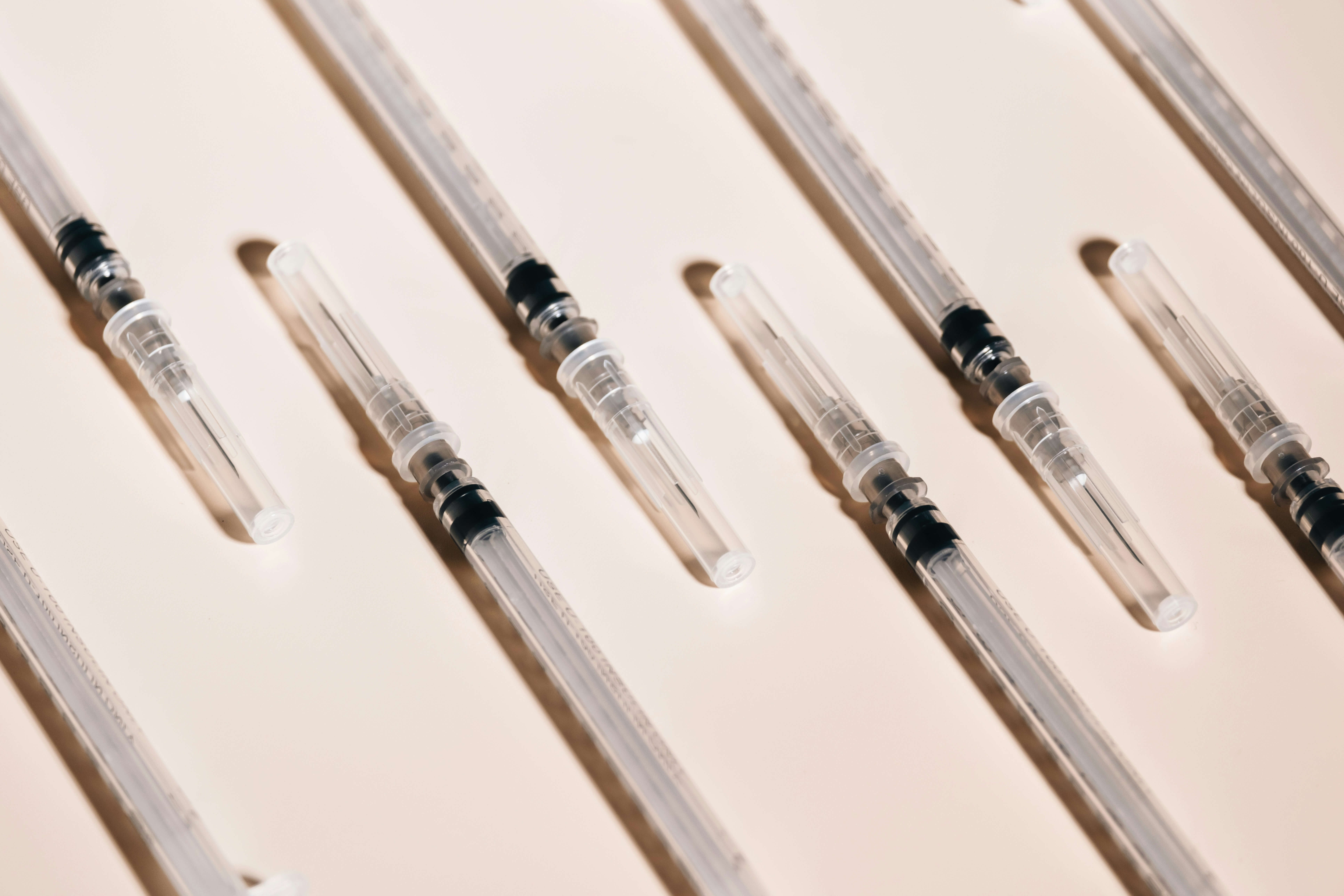 Sterile dermal filler syringes arranged on a neutral surface, representing different lip filler formulations