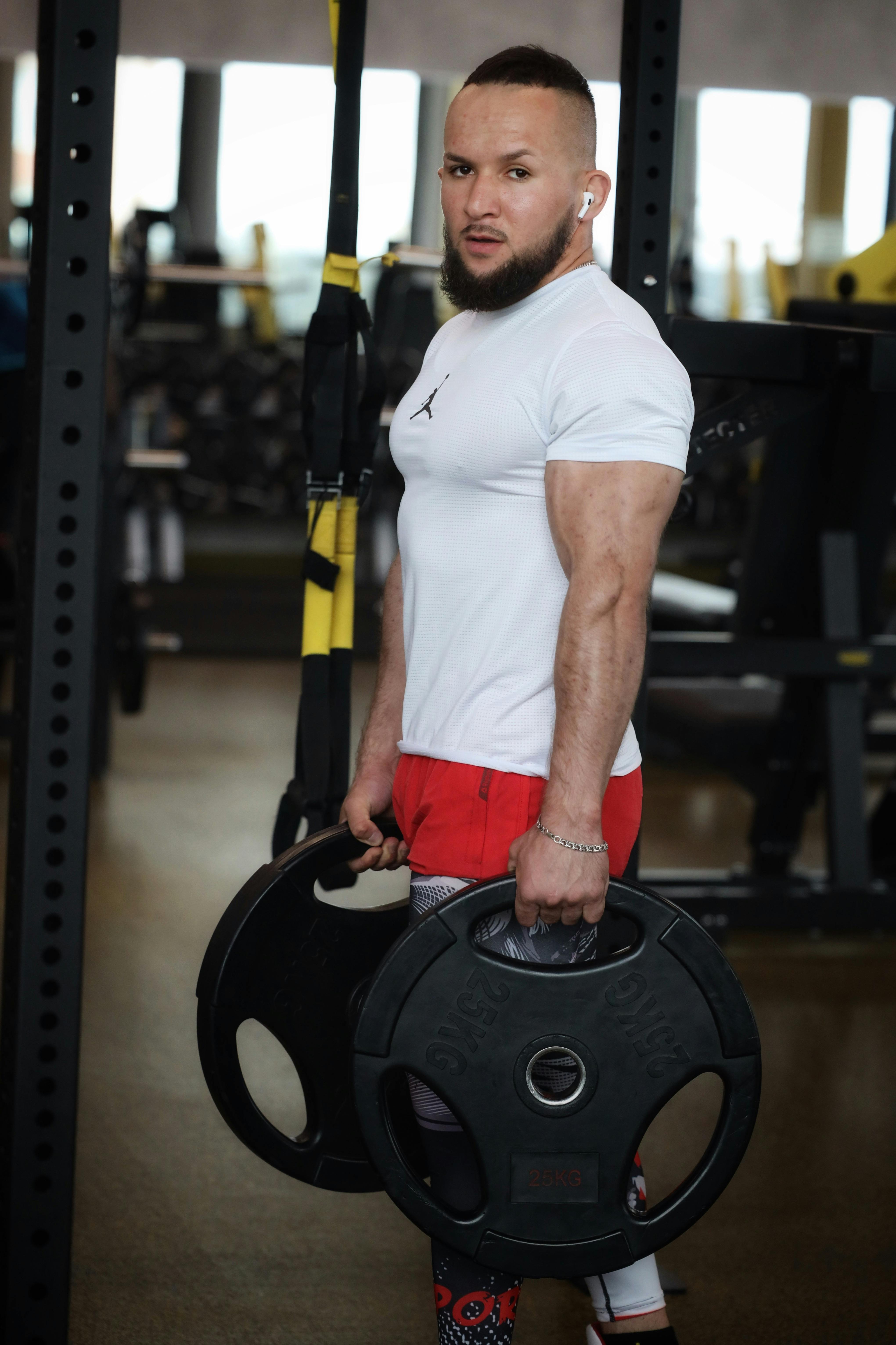 Bearded man lifting weights at the gym representing physical changes on testosterone replacement therapy