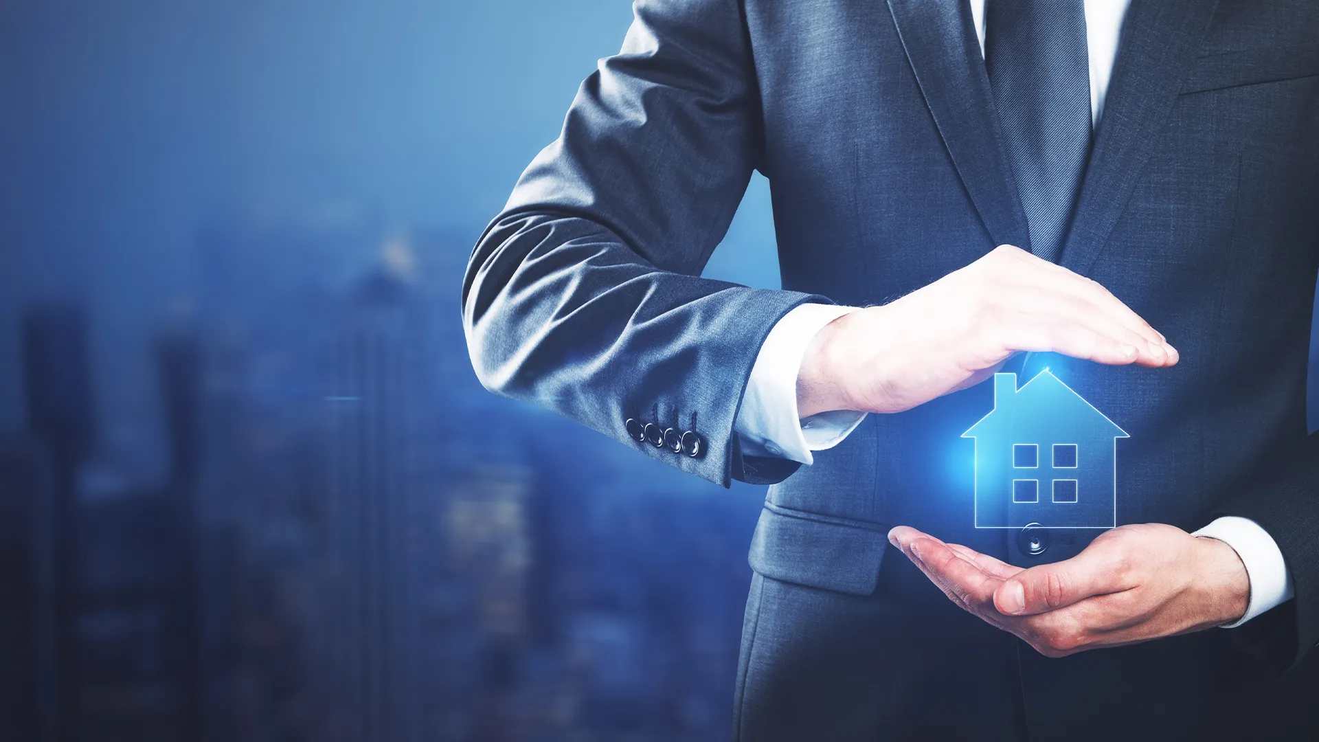 Person in suit holding a glowing blue icon of a house between their hands against a blurred city background.