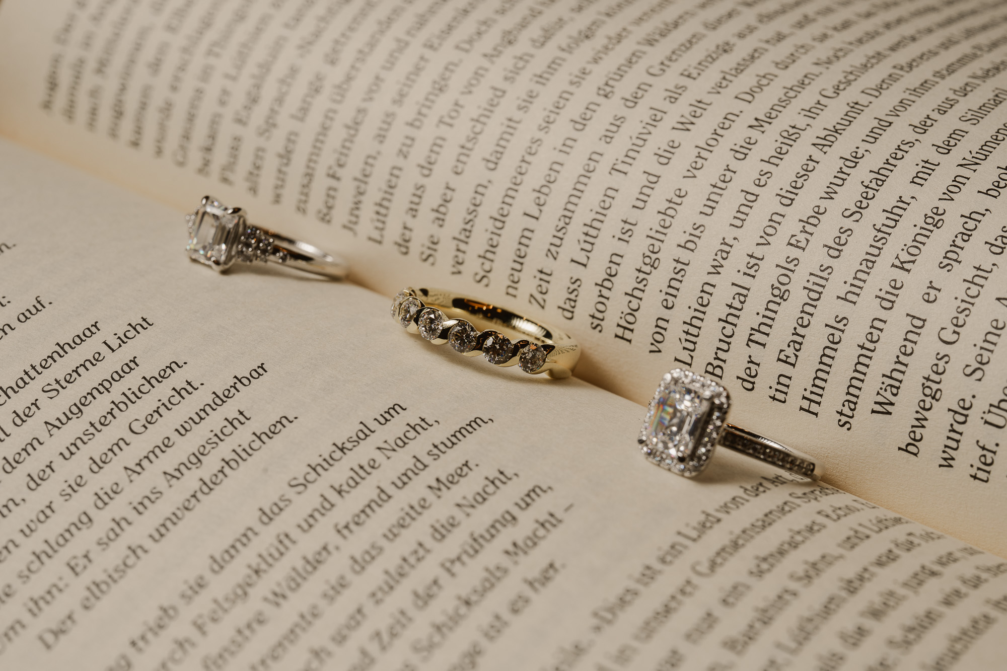 Delicate jewellery arranged across the printed pages of an open book.