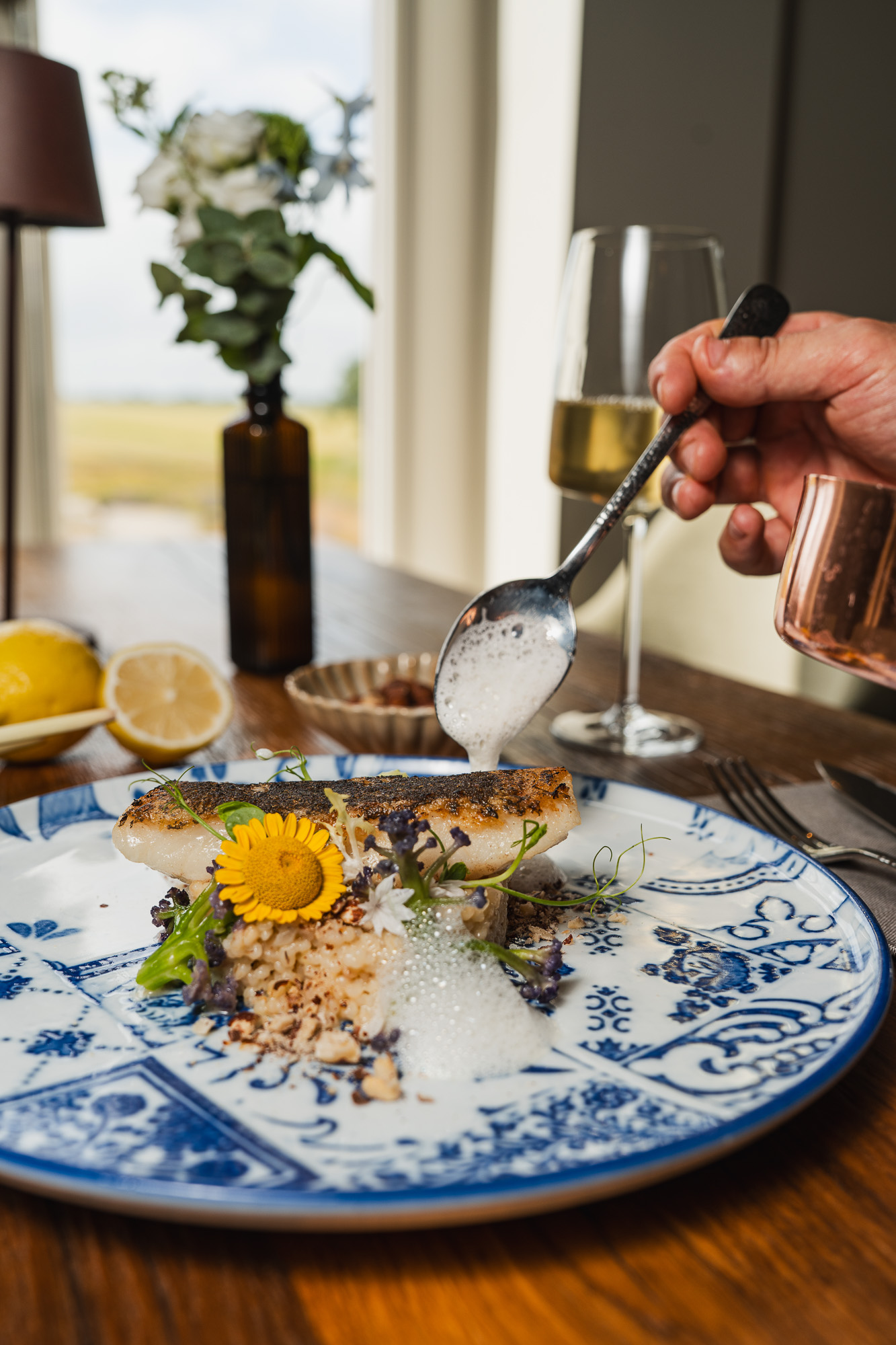 Restaurant dish on a blue ceramic plate with sauce being added at the table.