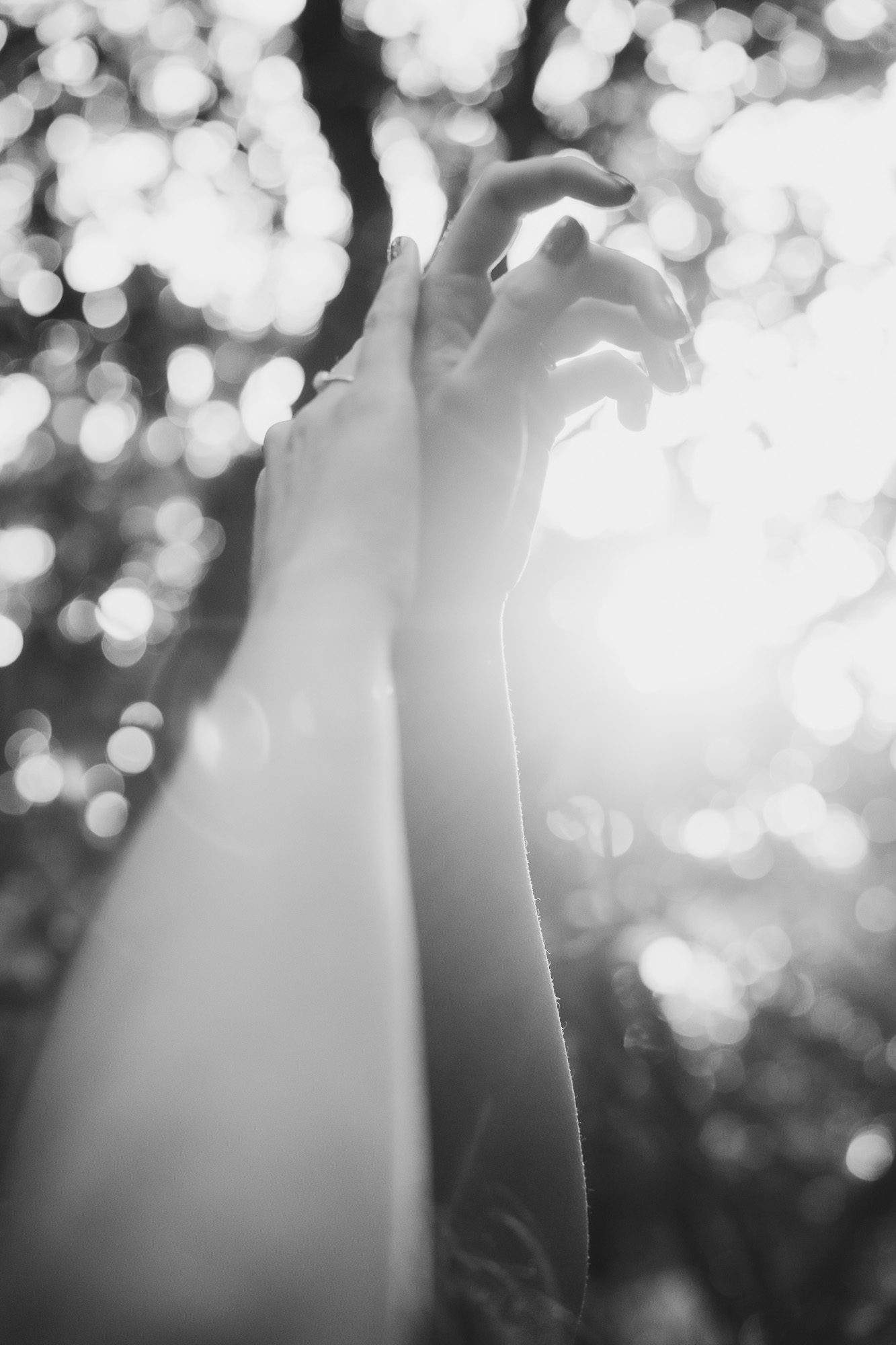 Black-and-white portrait of a woman surrounded by bright backlight and soft motion.