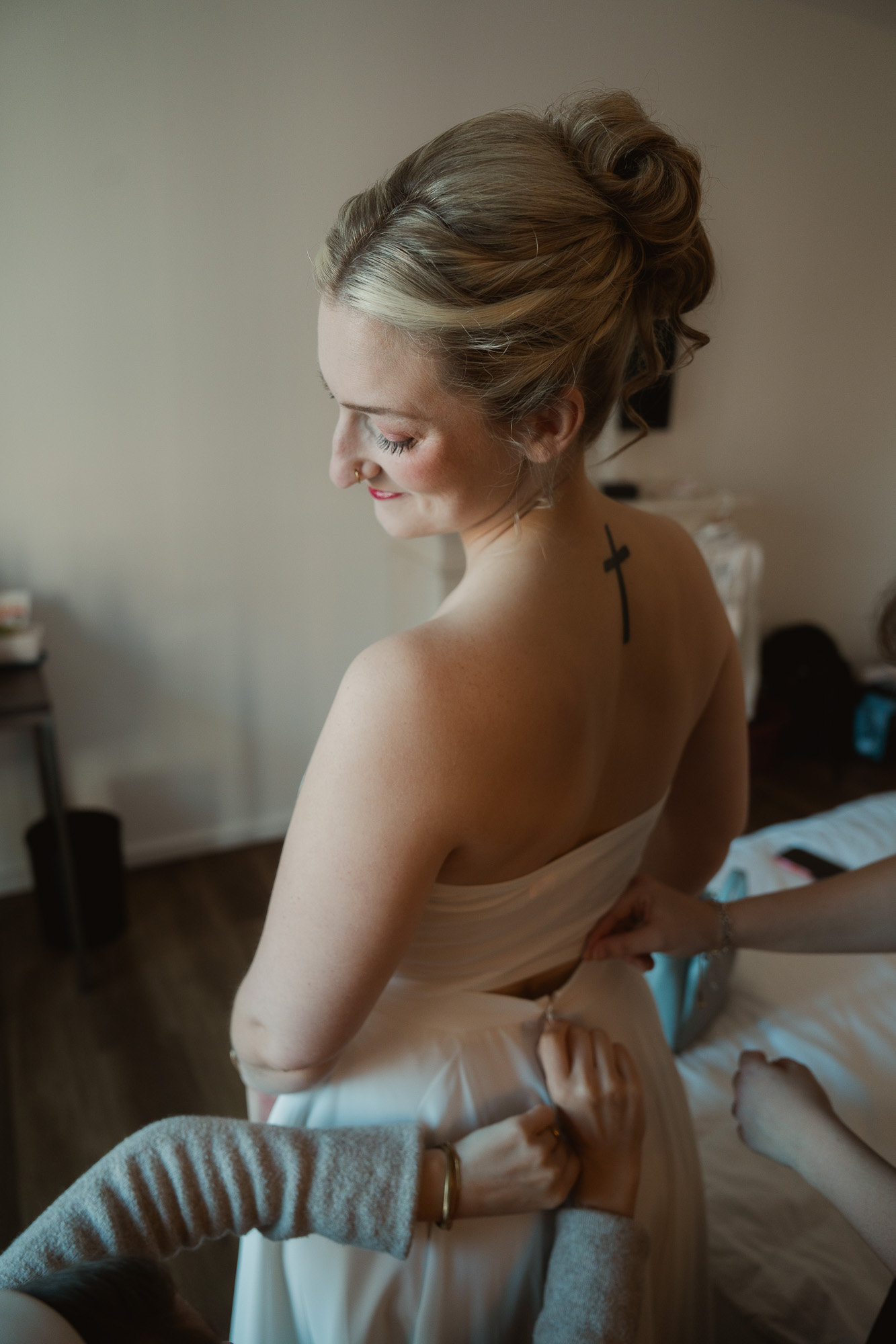 Bride sitting on the edge of a bed during wedding preparations.