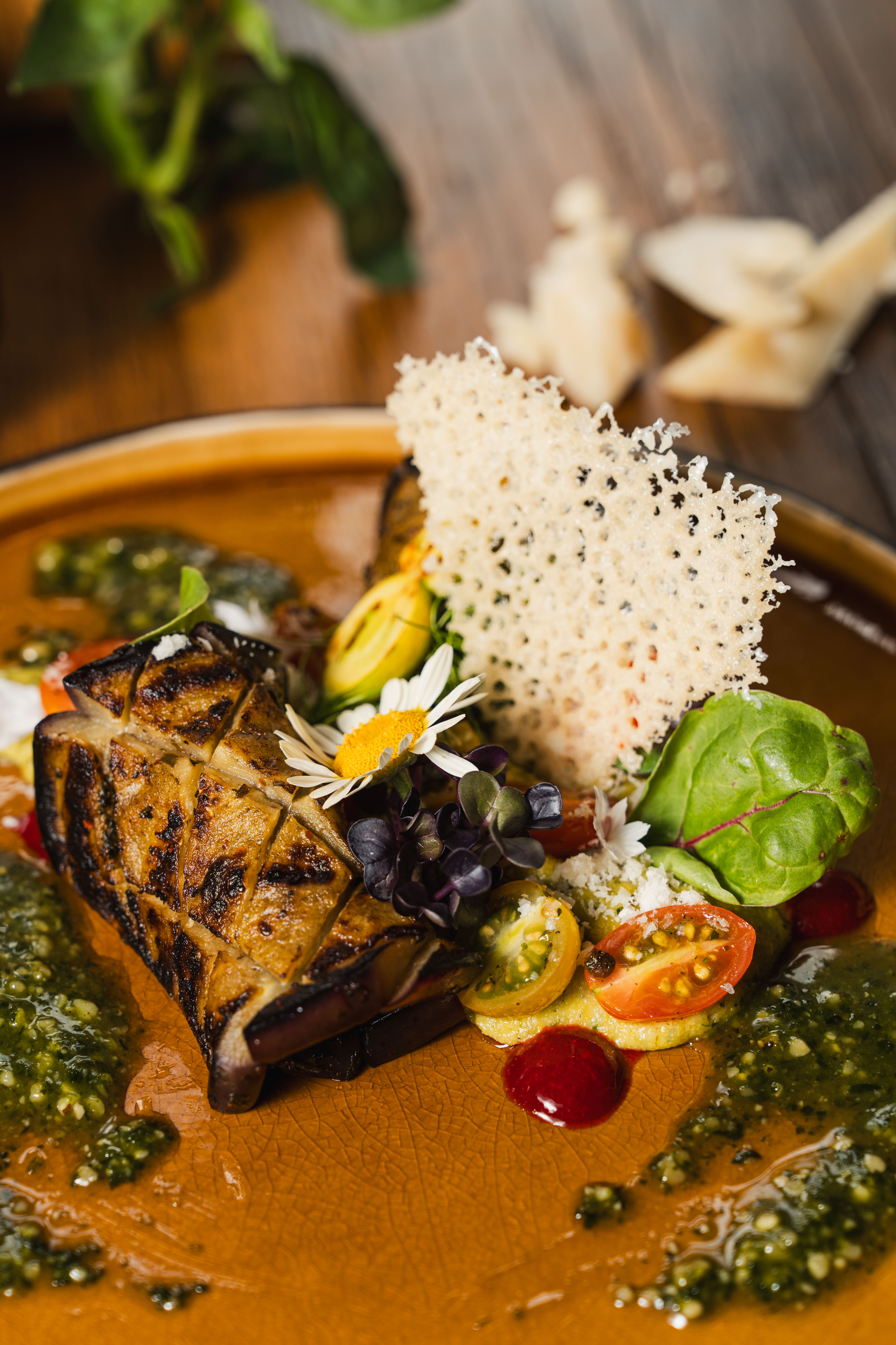 Close-up of a colourful vegetarian dish with grilled vegetables, herbs and edible flowers.