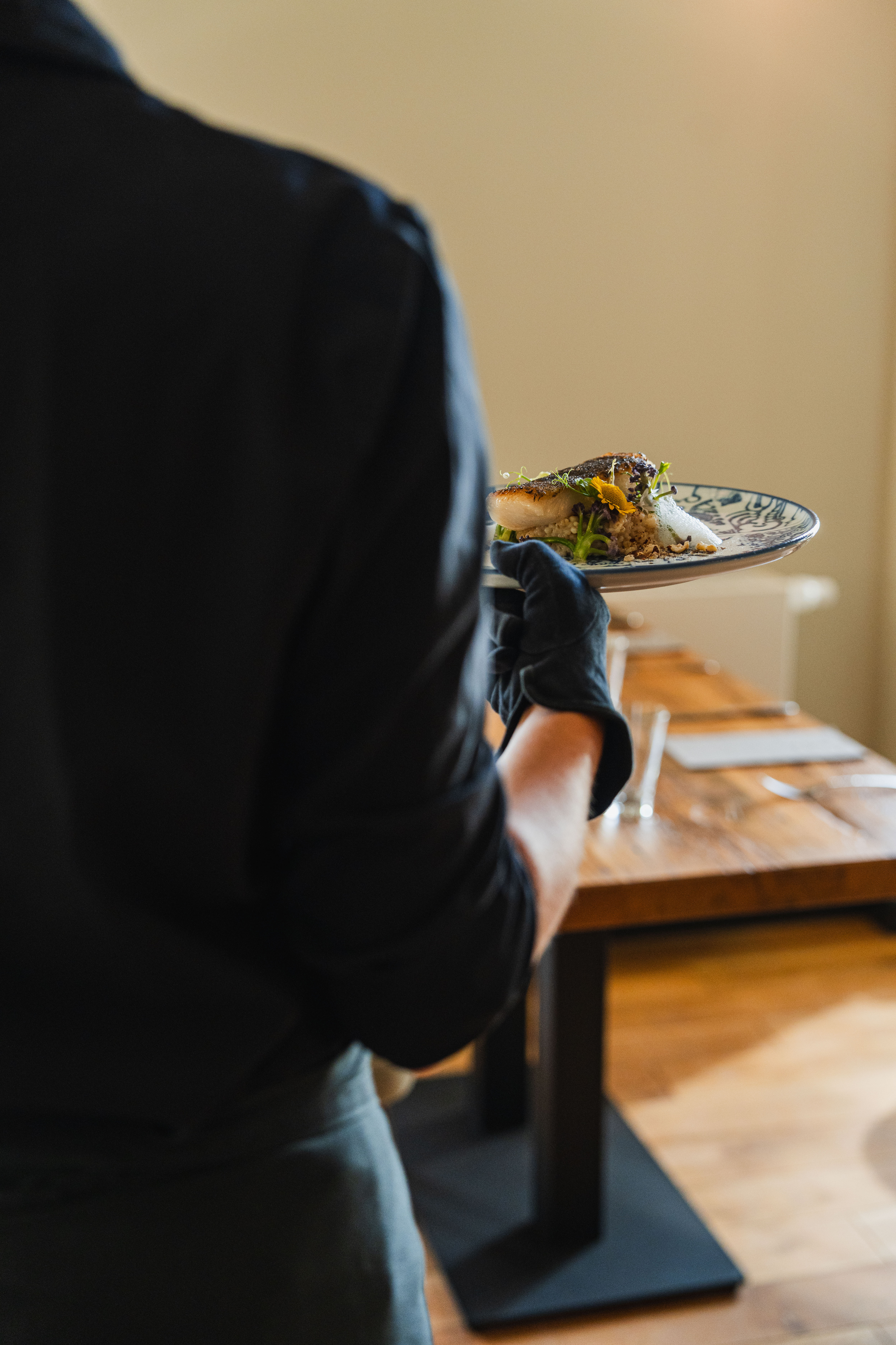 Tammenshof employee carrying a freshly prepared dish through the restaurant.