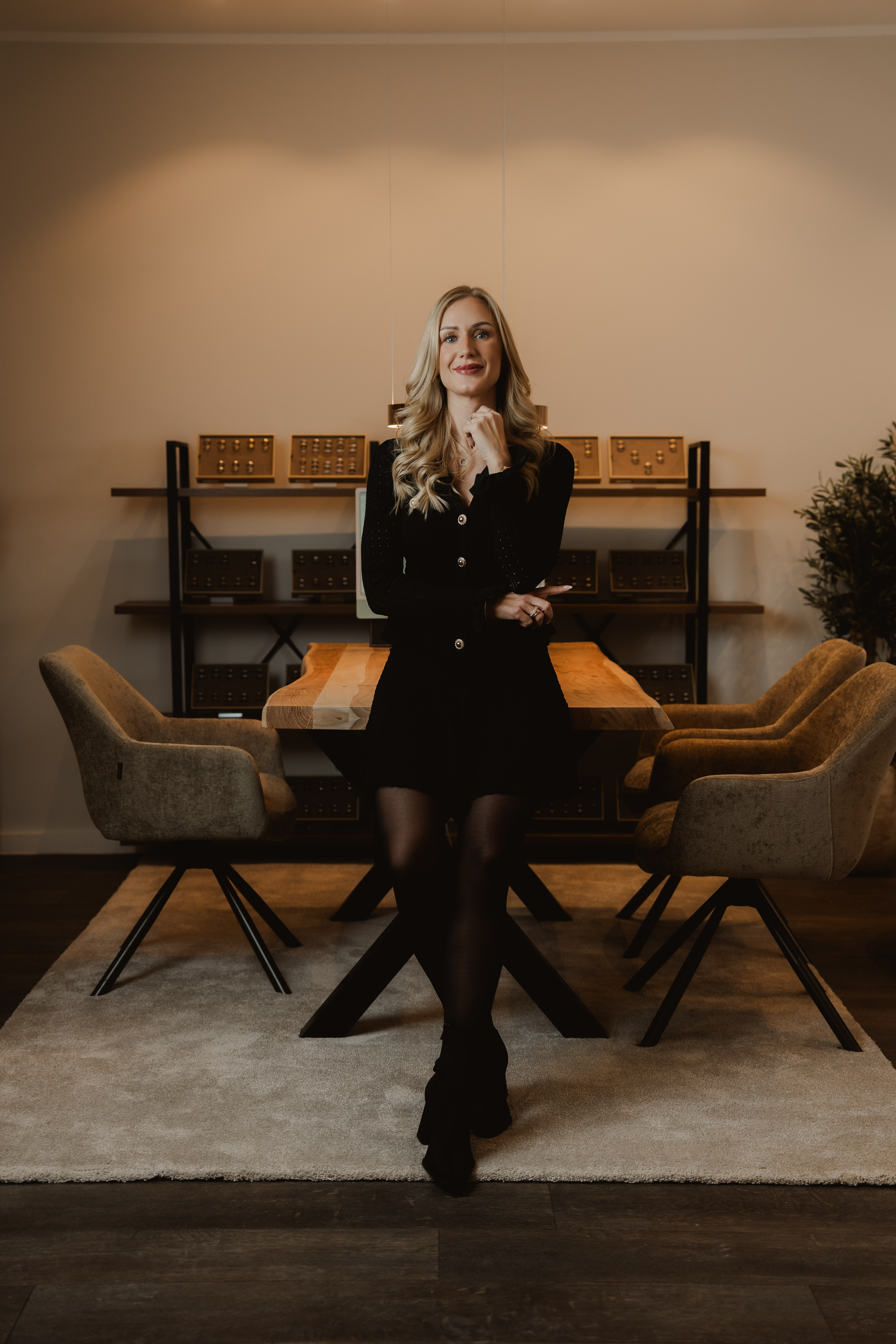 Full-length portrait of a blonde woman standing inside the Traumringe jewellery store.