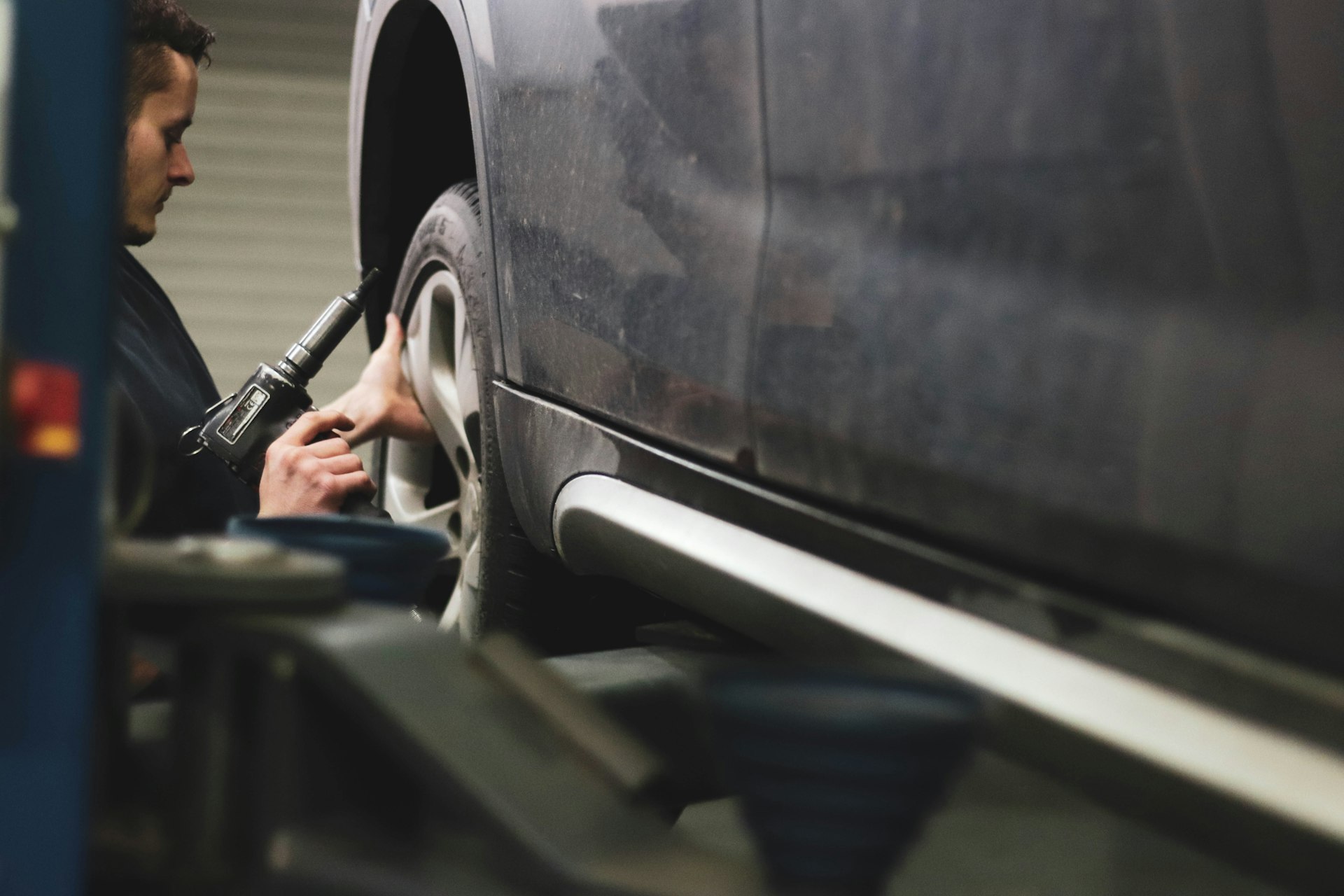 Mechanic working under vehicle on alignment