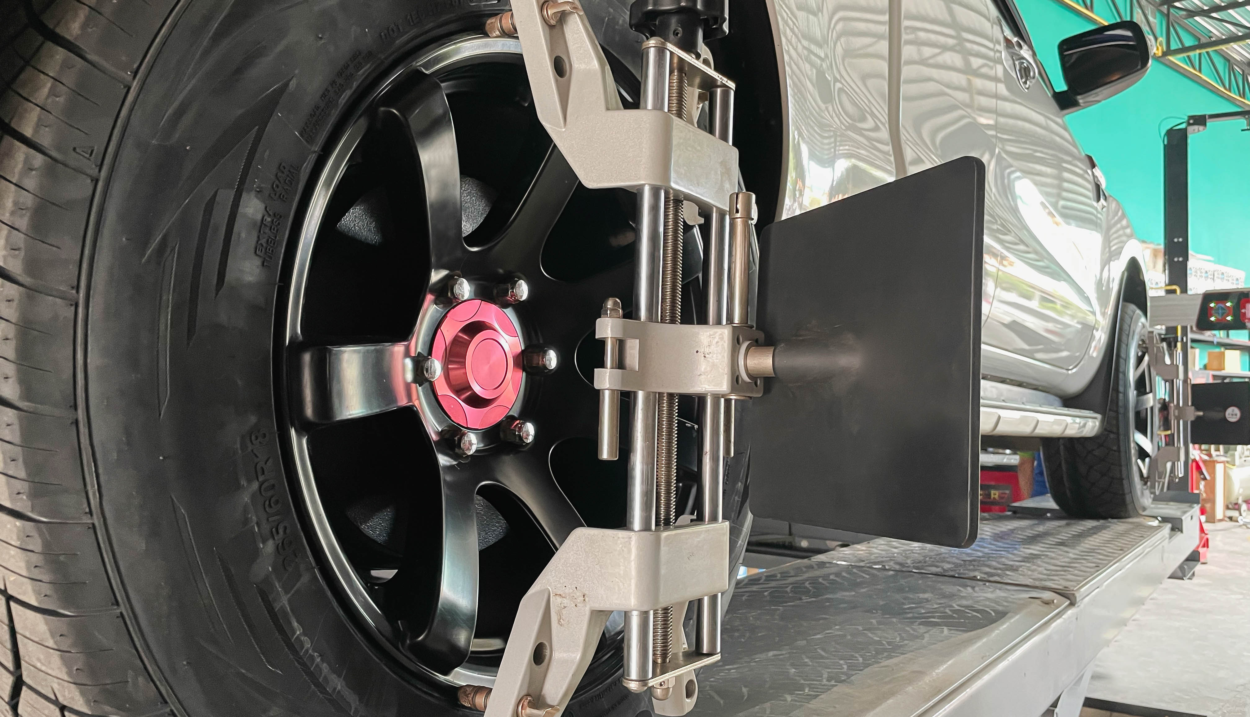 Professional wheel alignment in progress at Redline Auto Creations