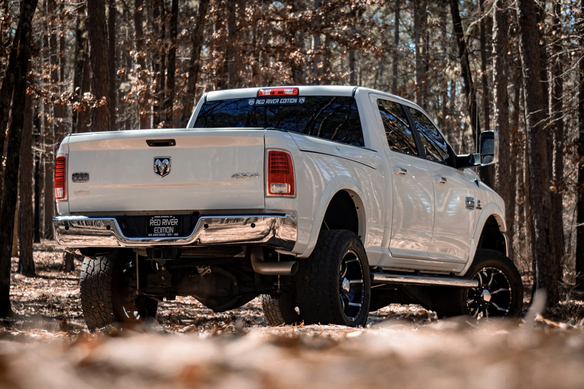White Dodge truck with lift kit and custom wheels