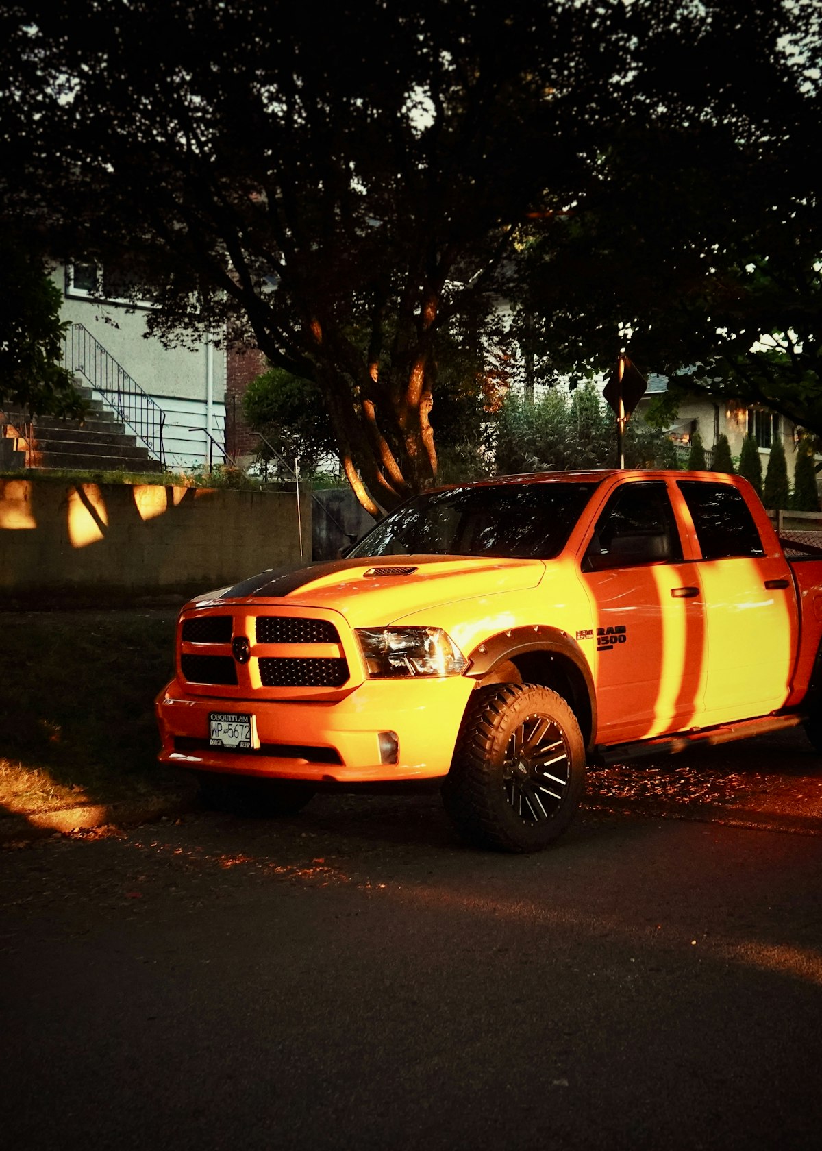 Orange and white pickup truck with custom wheels
