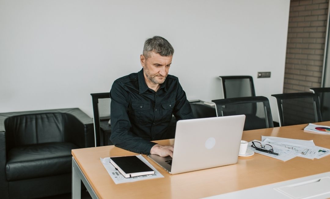 Propriétaire de petite entreprise qui consulte son site vitrine professionnel sur un ordinateur portable