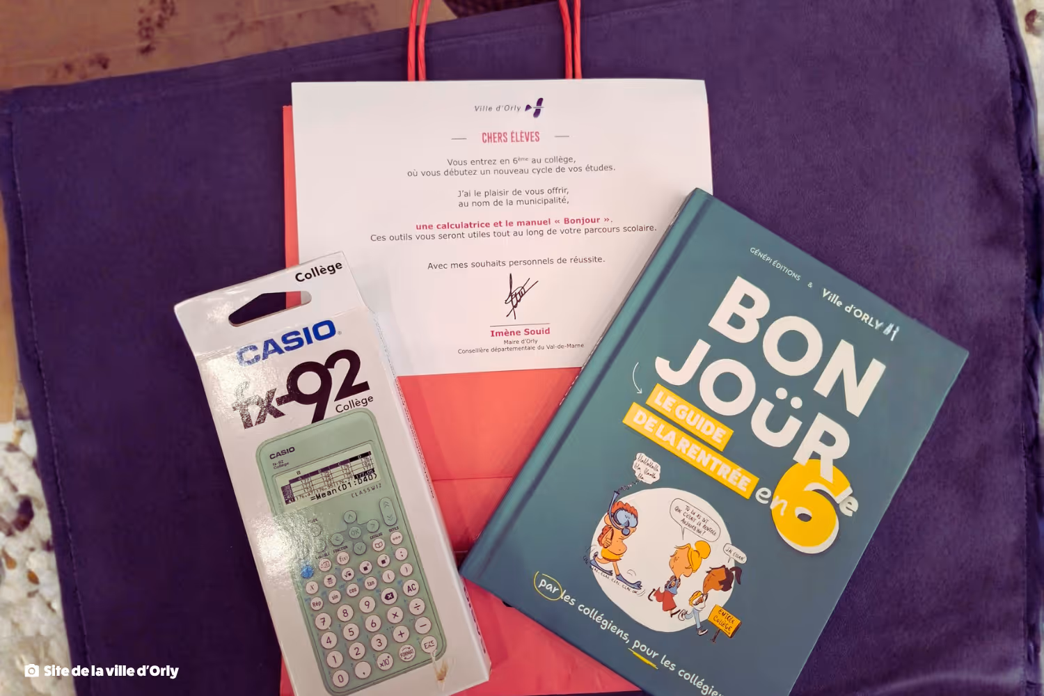 Un paquet de calculatrice Casio fx-92, un manuel intitulé « Bonjour le guide de la rentrée en 6e » et une lettre adressée aux élèves de 6e de la ville d'Orly.