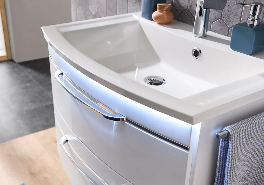 White bathroom sink with modern faucet and towel hanging on the side.