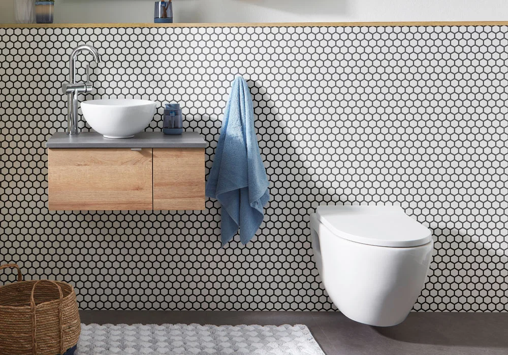 Modern bathroom with a wall-mounted sink, a blue towel, and a wall-mounted toilet.