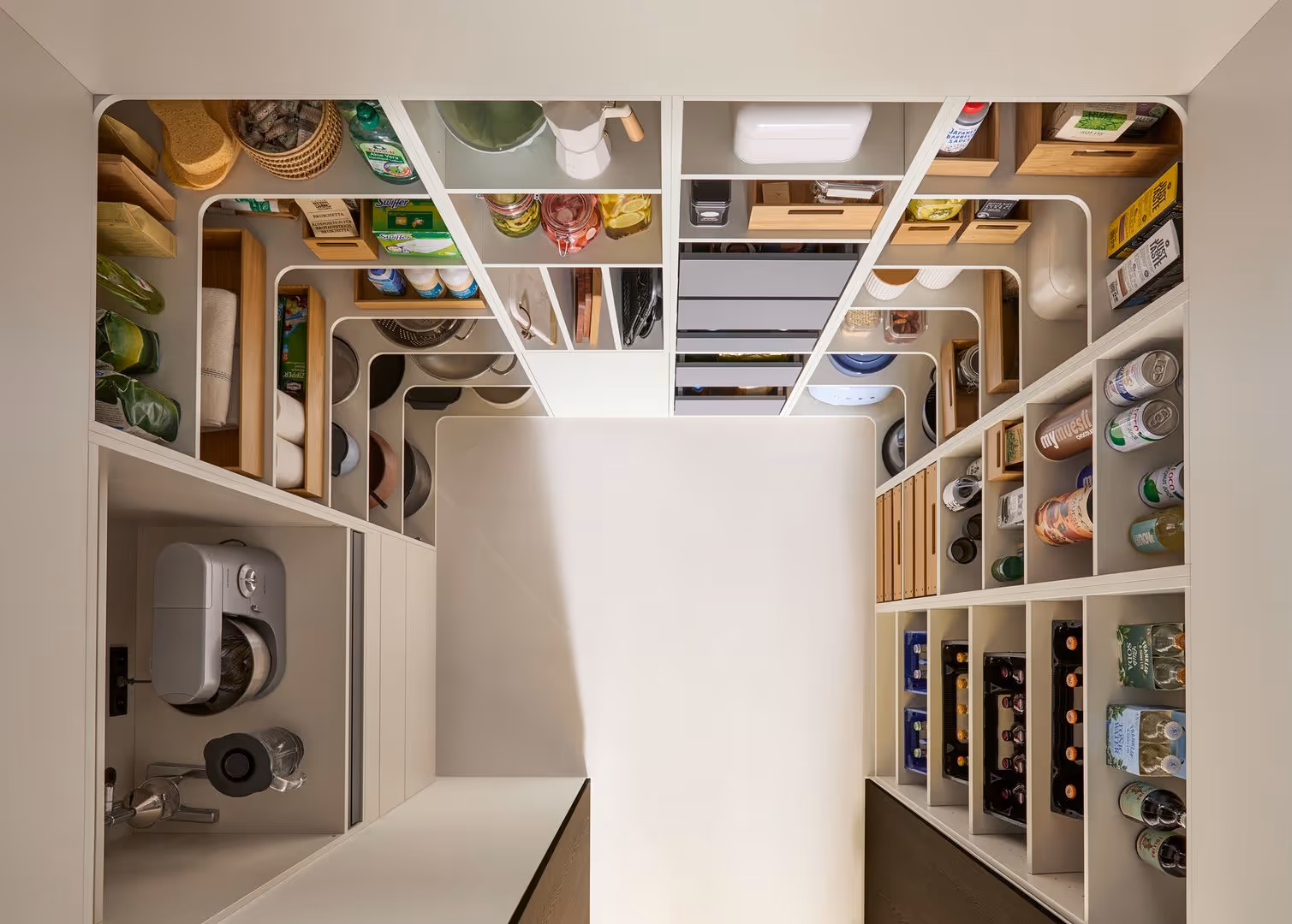 Organized pantry shelves filled with jars, cans, and kitchen items neatly arranged in compartments.