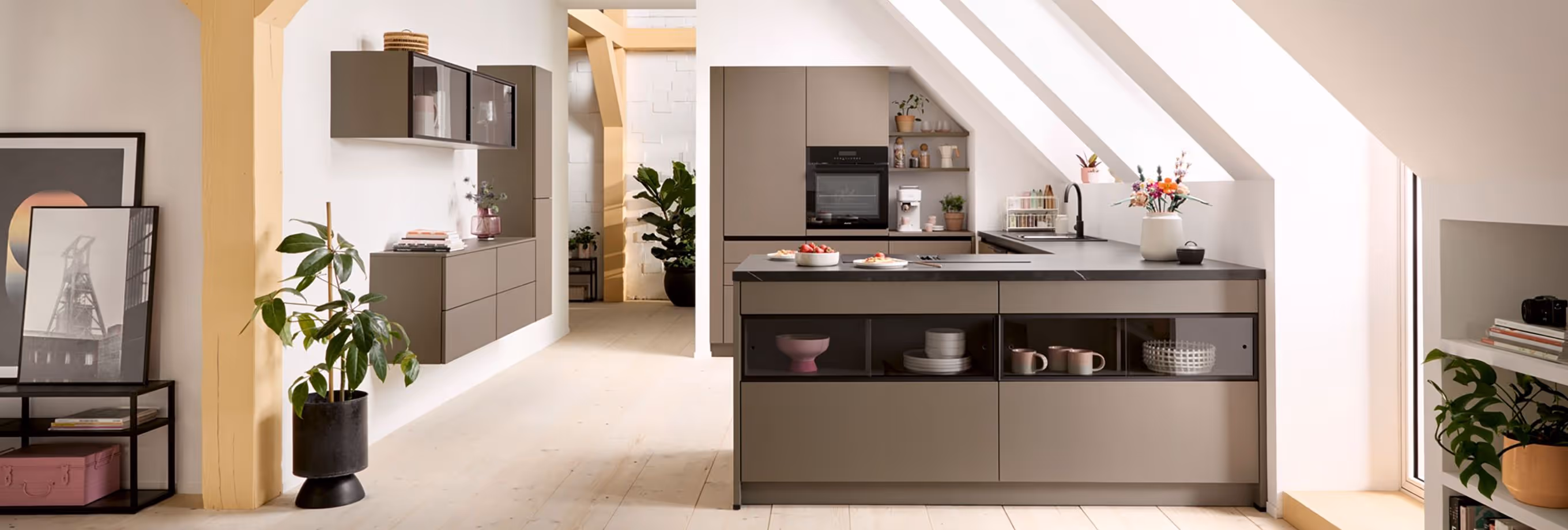 Modern kitchen with sleek cabinets, a central island, and large slanted windows allowing natural light.