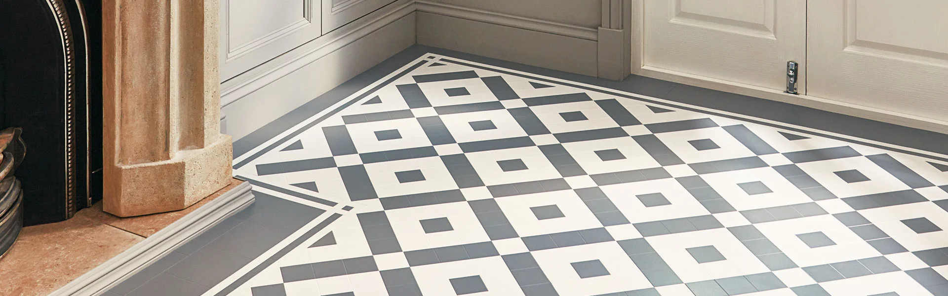 Geometric black and white tile floor with a square pattern in a room corner.