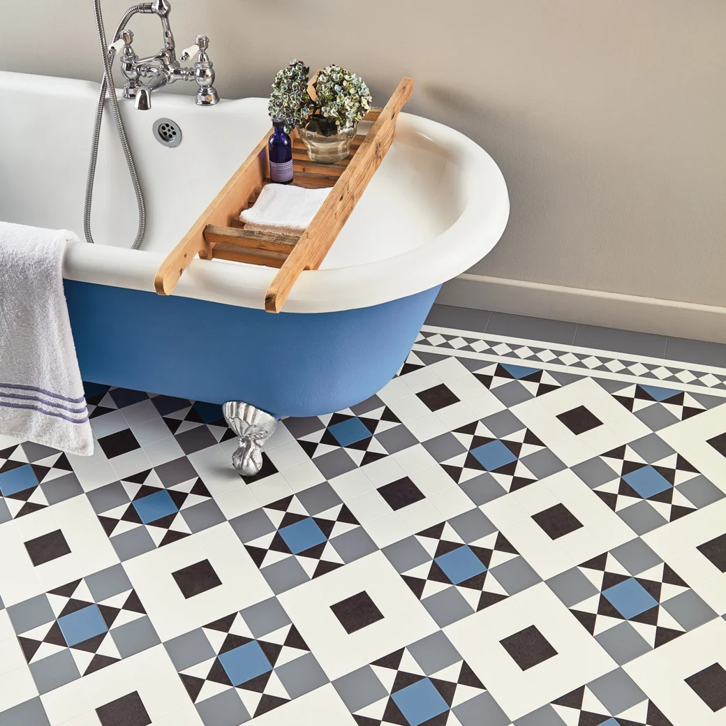 Blue bathtub with a wooden tray, next to a patterned tile floor with geometric shapes.