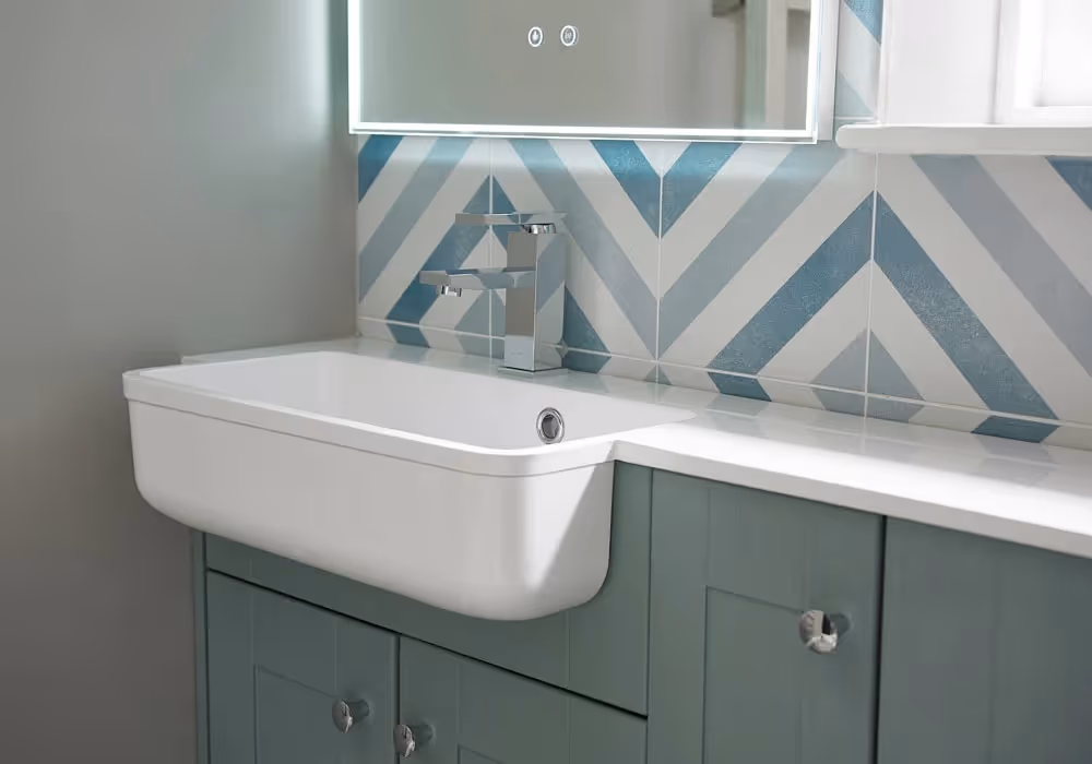 Bathroom sink with a chrome faucet, set against blue and white chevron-patterned tiles.