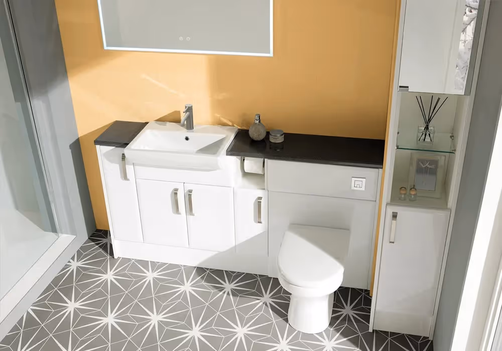 Modern bathroom with white sink, toilet, and cabinets against a yellow wall. Geometric tile flooring.