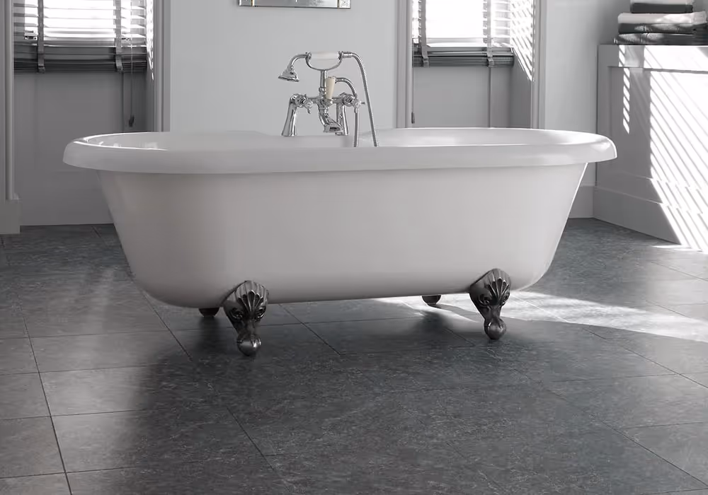 A white clawfoot bathtub is placed on a tiled floor in a well-lit bathroom.
