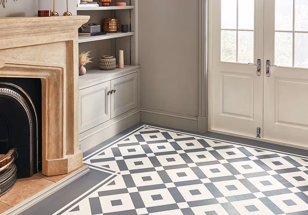 A patterned black-and-white tiled floor in a bright room with a fireplace.