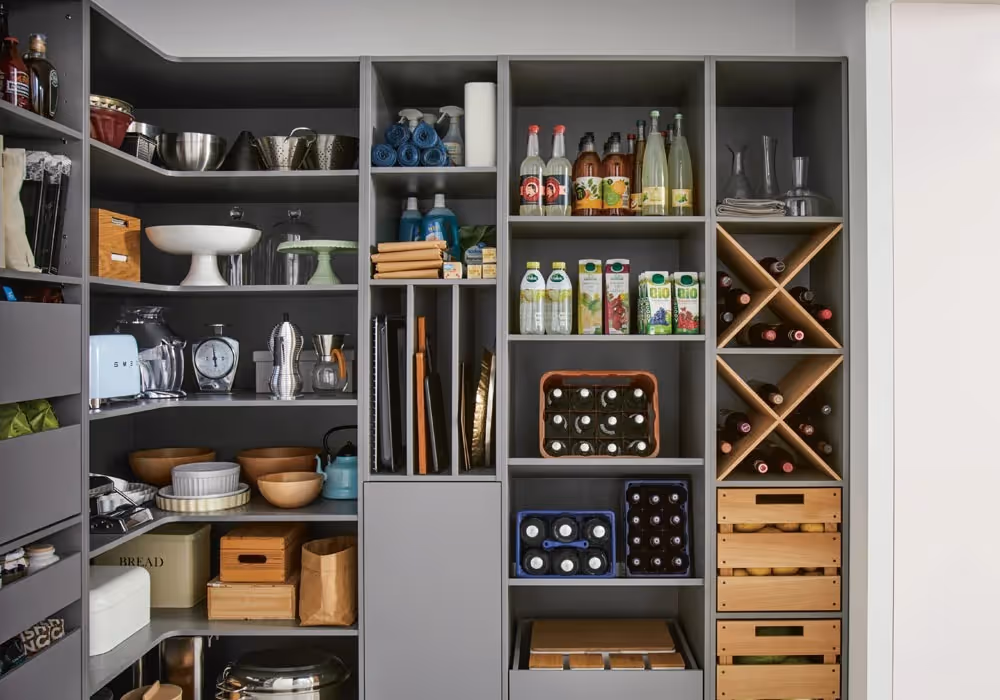 Organized pantry shelves with various foods, drinks, and kitchenware neatly arranged in compartments and racks.