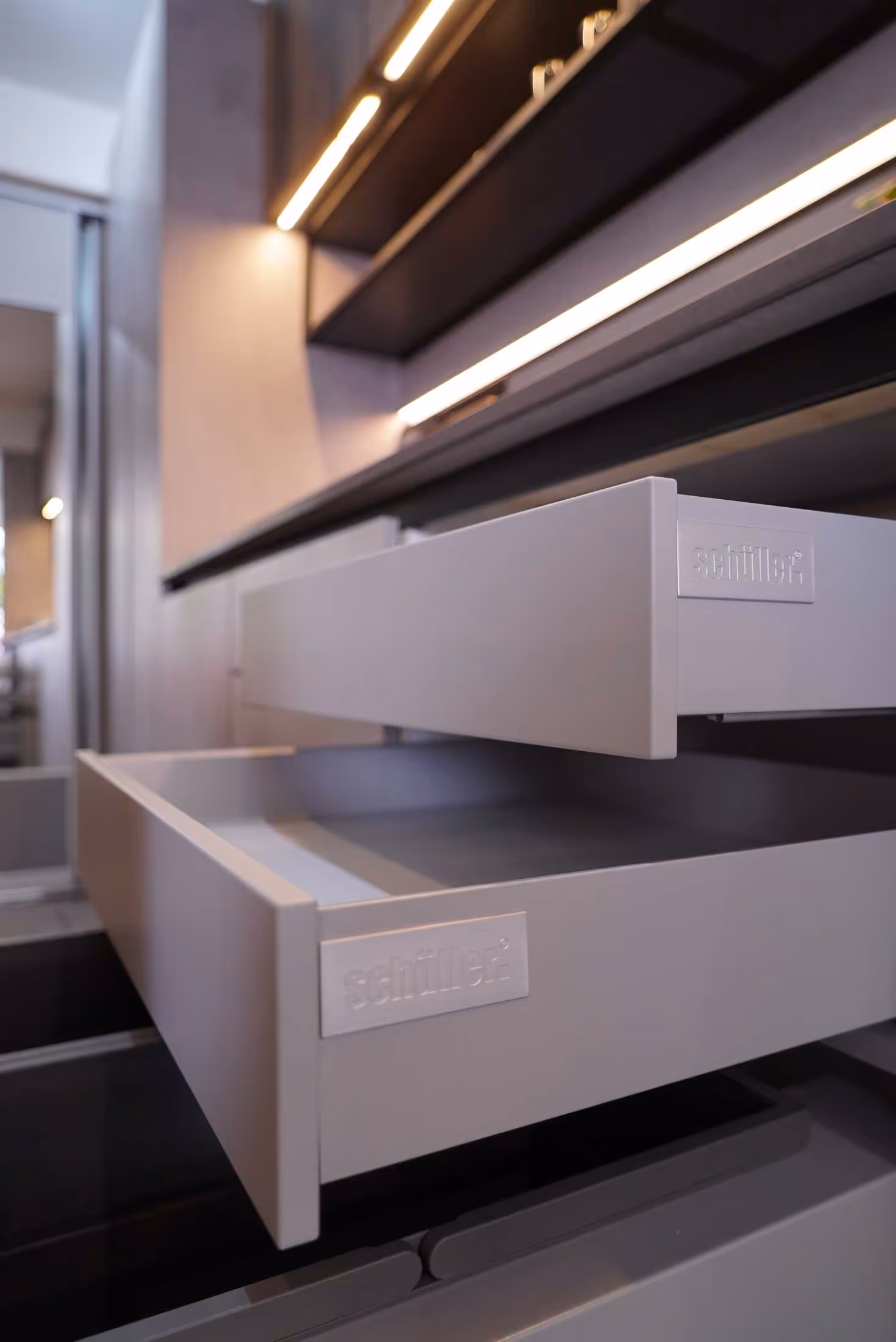 Open kitchen drawers with labels, showing clean lines and minimalistic design.