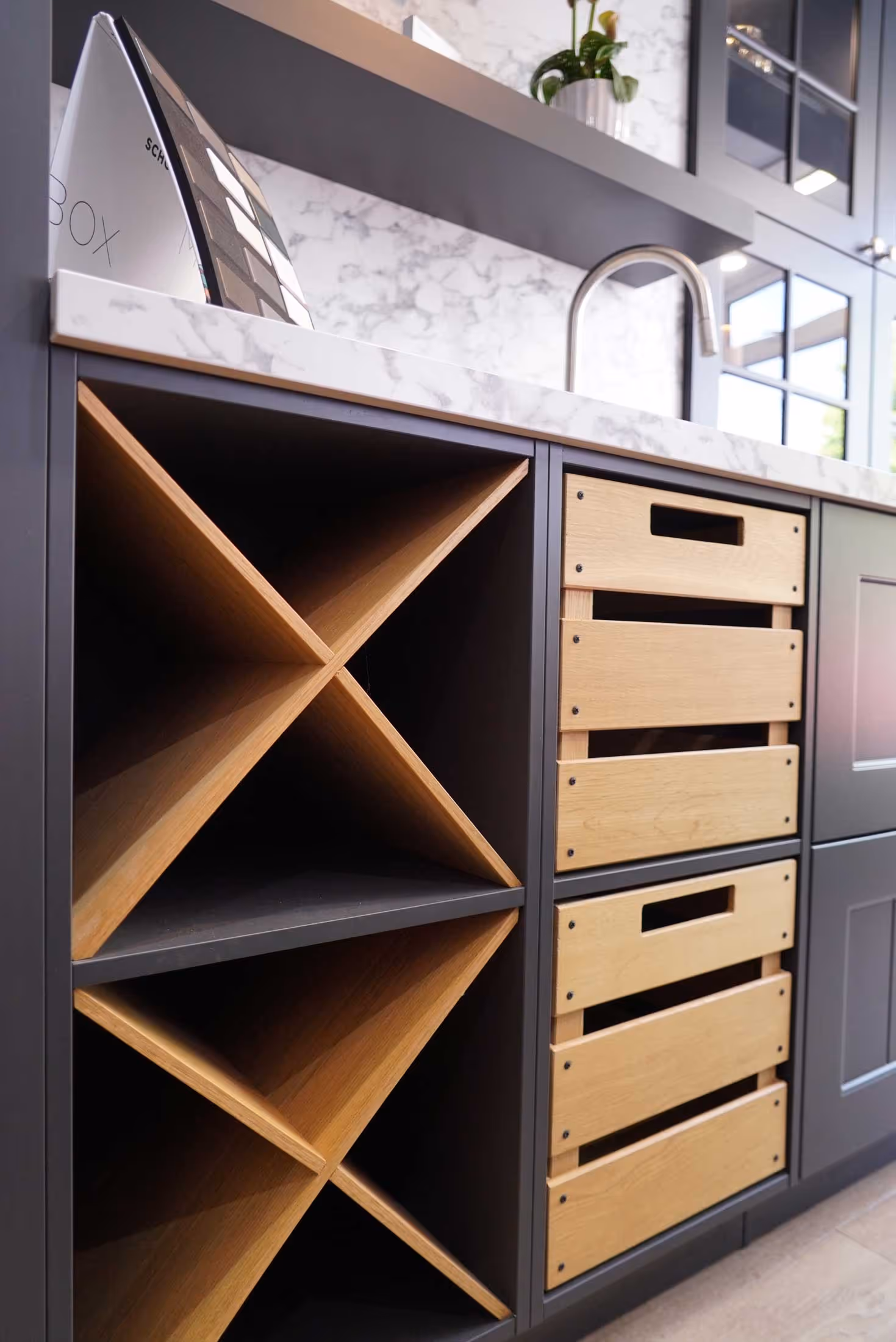 A kitchen area with a sink, wooden storage boxes, and a wine rack.